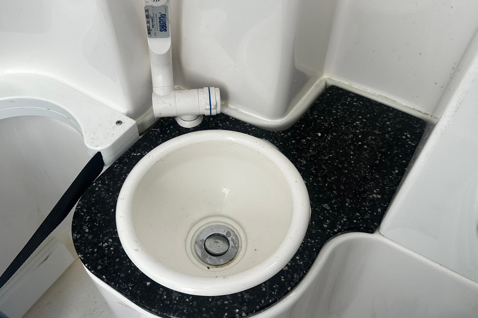Boat sink with black speckled countertop in 2002 Sea Fox 228 Commander.