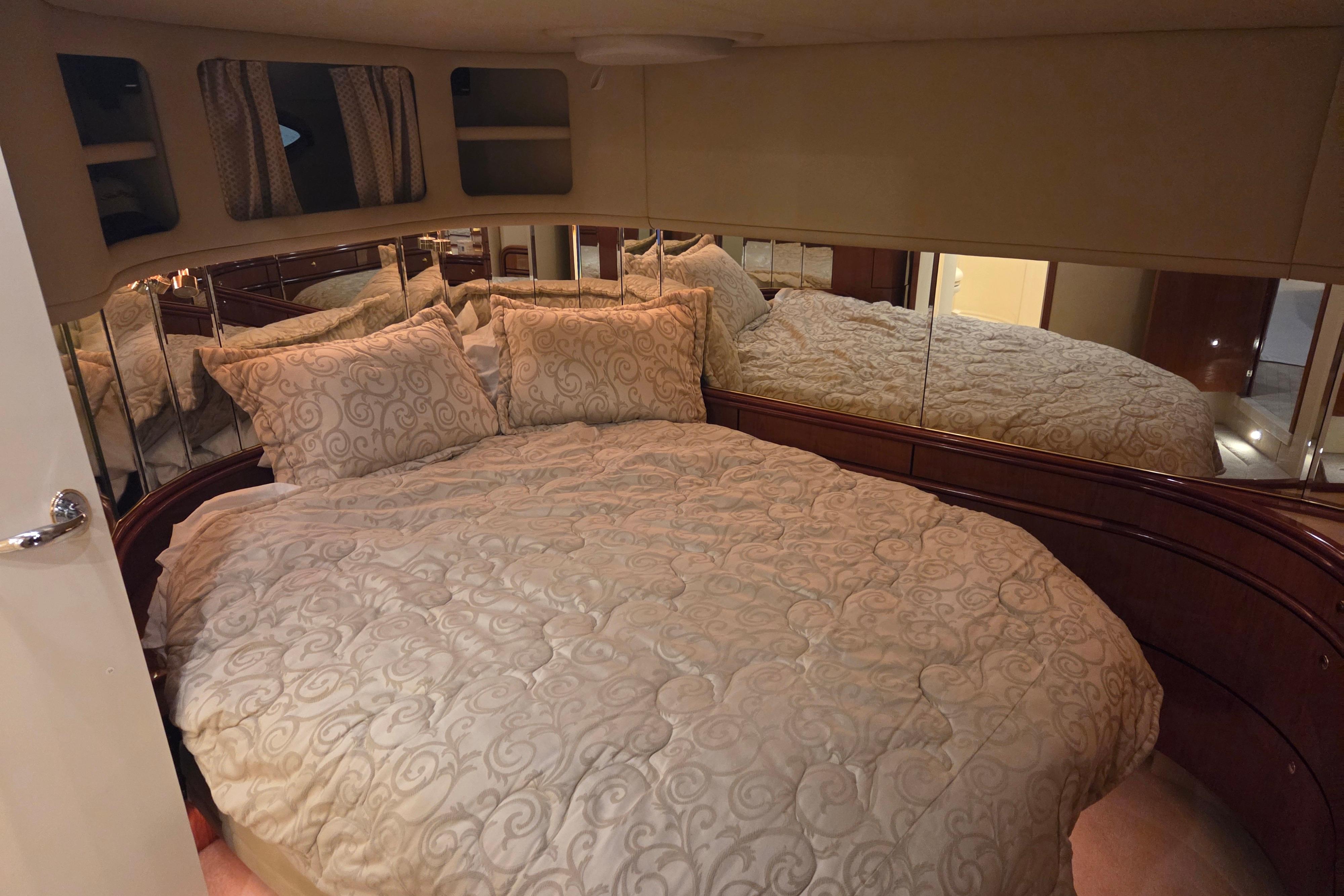 Luxurious bedroom interior of 2000 Sea Ray Sundancer 540 yacht with elegant bedding.