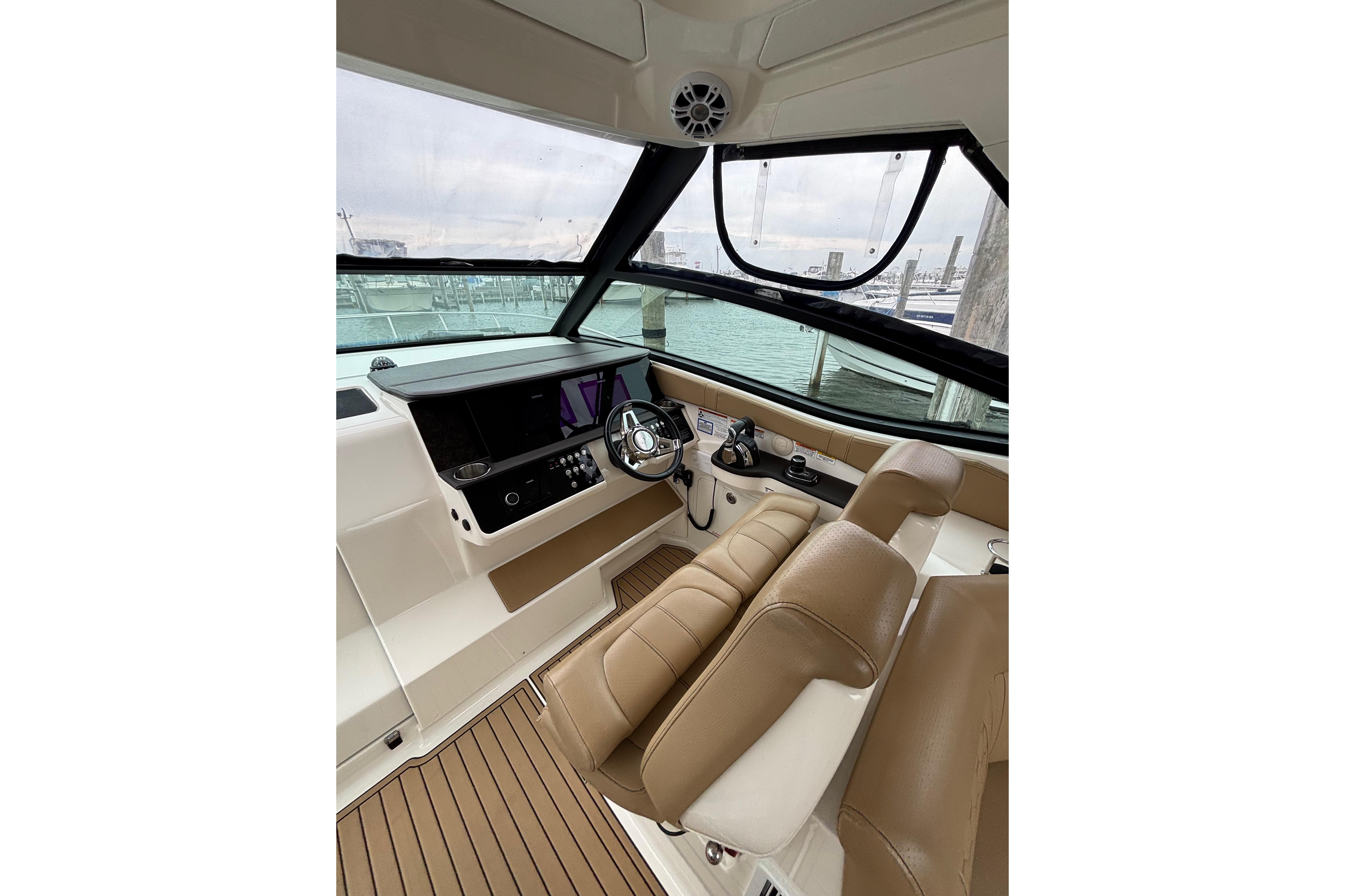 2021 Sea Ray Sundancer 320 Outboard helm with leather seats and modern controls.