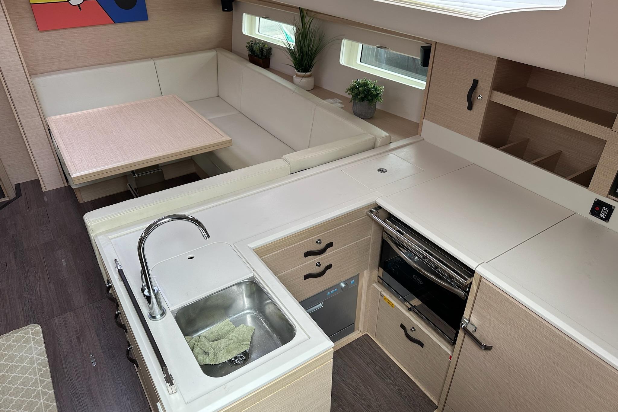 Modern kitchen and dining area in 2018 Jeanneau 51 yacht, featuring sleek design and ample storage.
