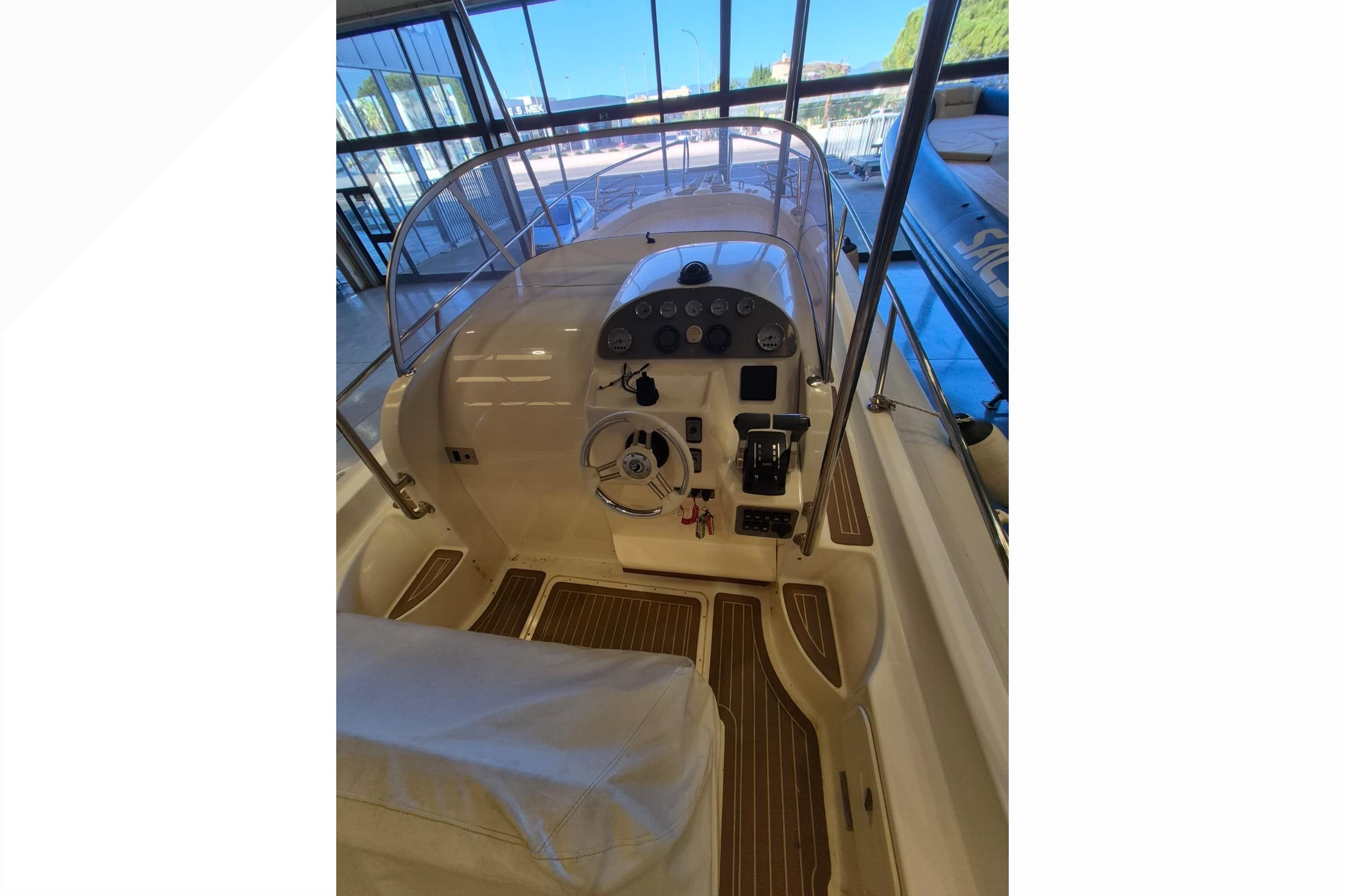 2012 Capelli Tempest 900 boat cockpit with steering wheel and control panel.