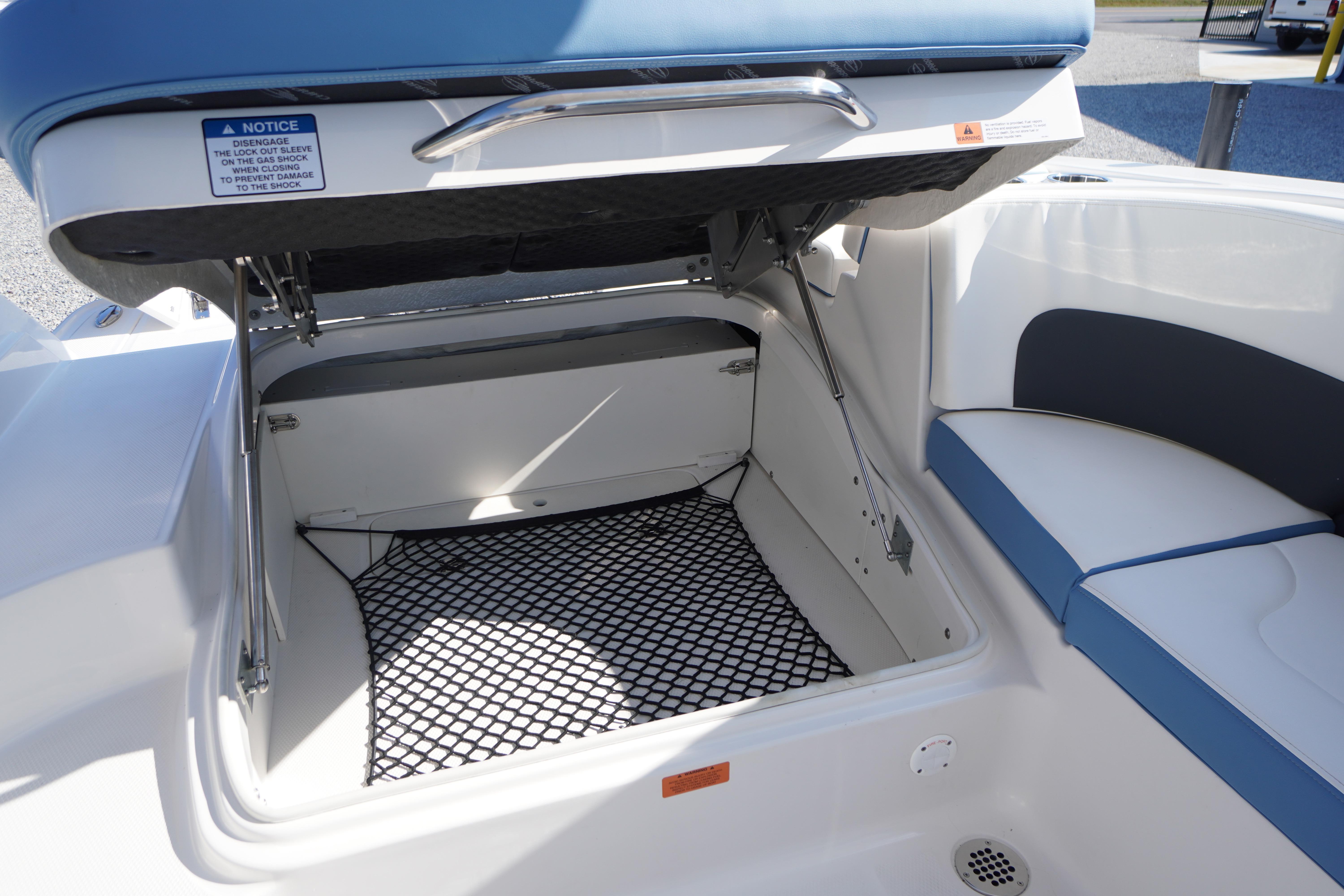 Open storage compartment on 2026 Chaparral 270 OSX boat with cushioned seating.