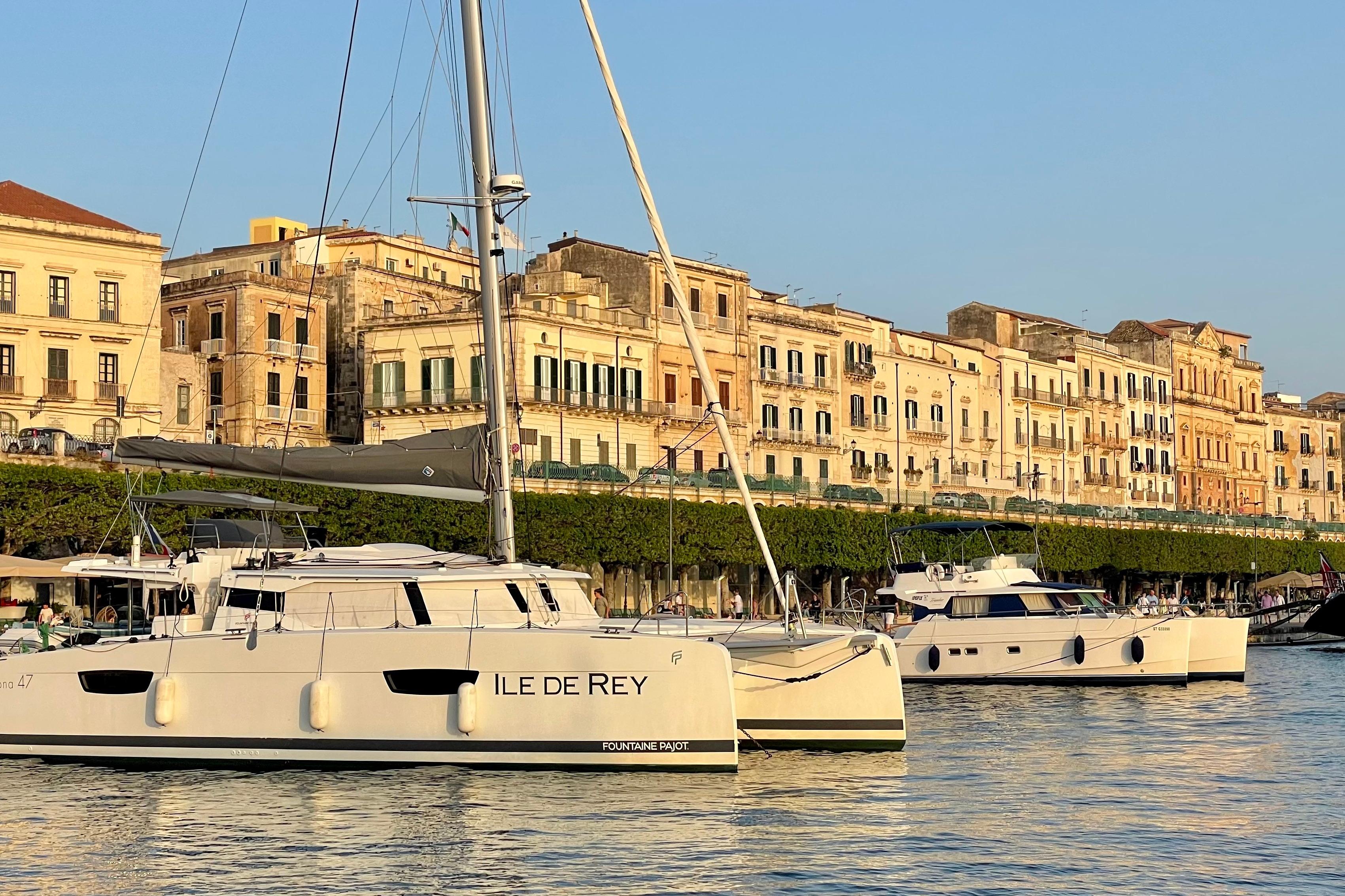 2020 Fountaine Pajot Saona 47 catamaran docked near historic waterfront buildings.