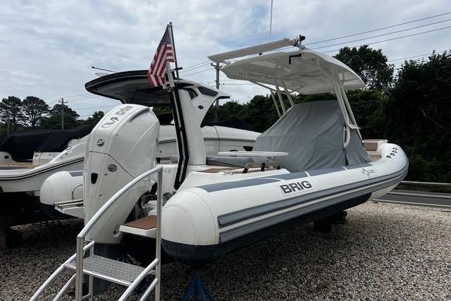 2022 Brig Eagle 8 boat with canopy and American flag, displayed outdoors.
