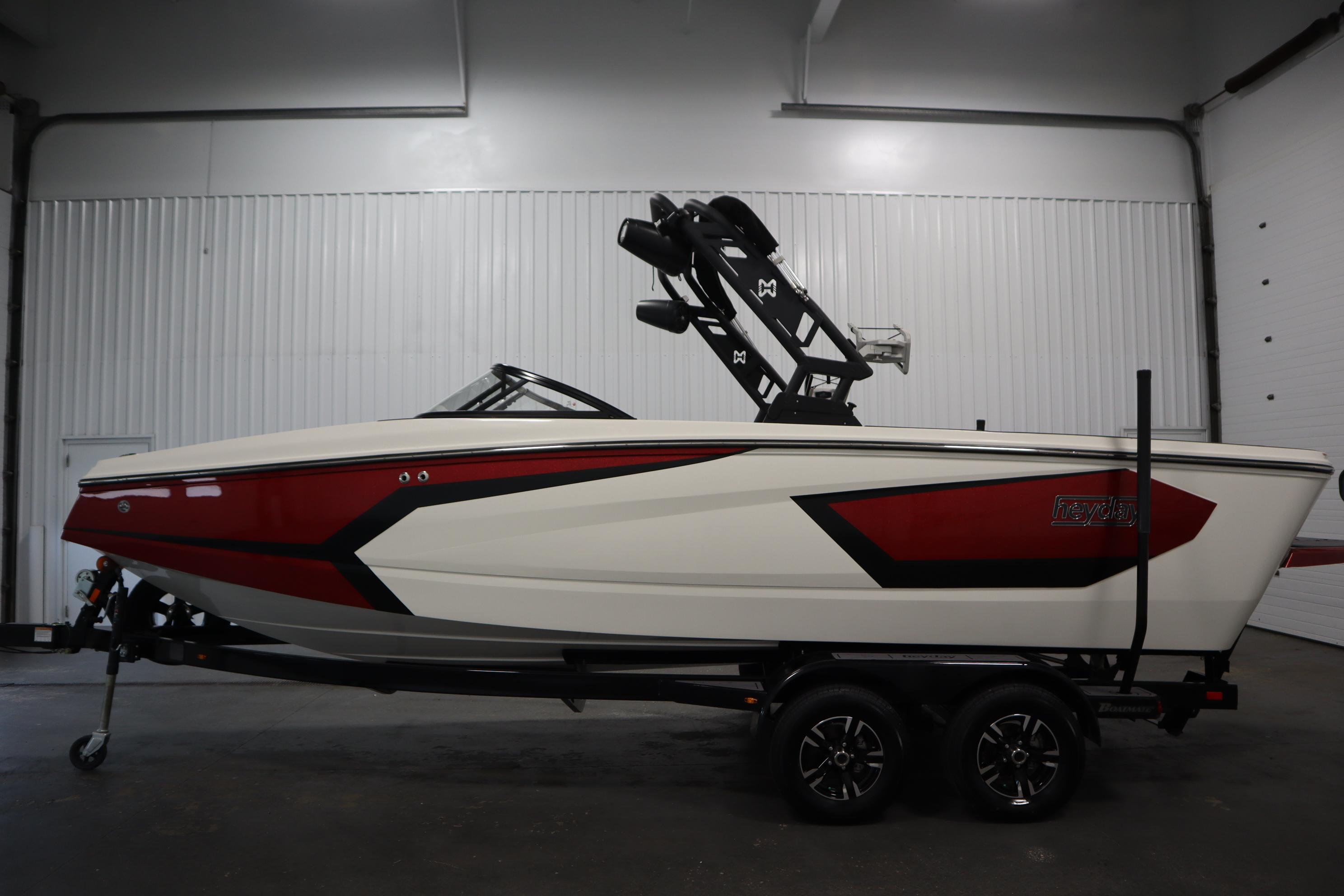 2023 Heyday WT Surf boat in a showroom, featuring a sleek red and white design.