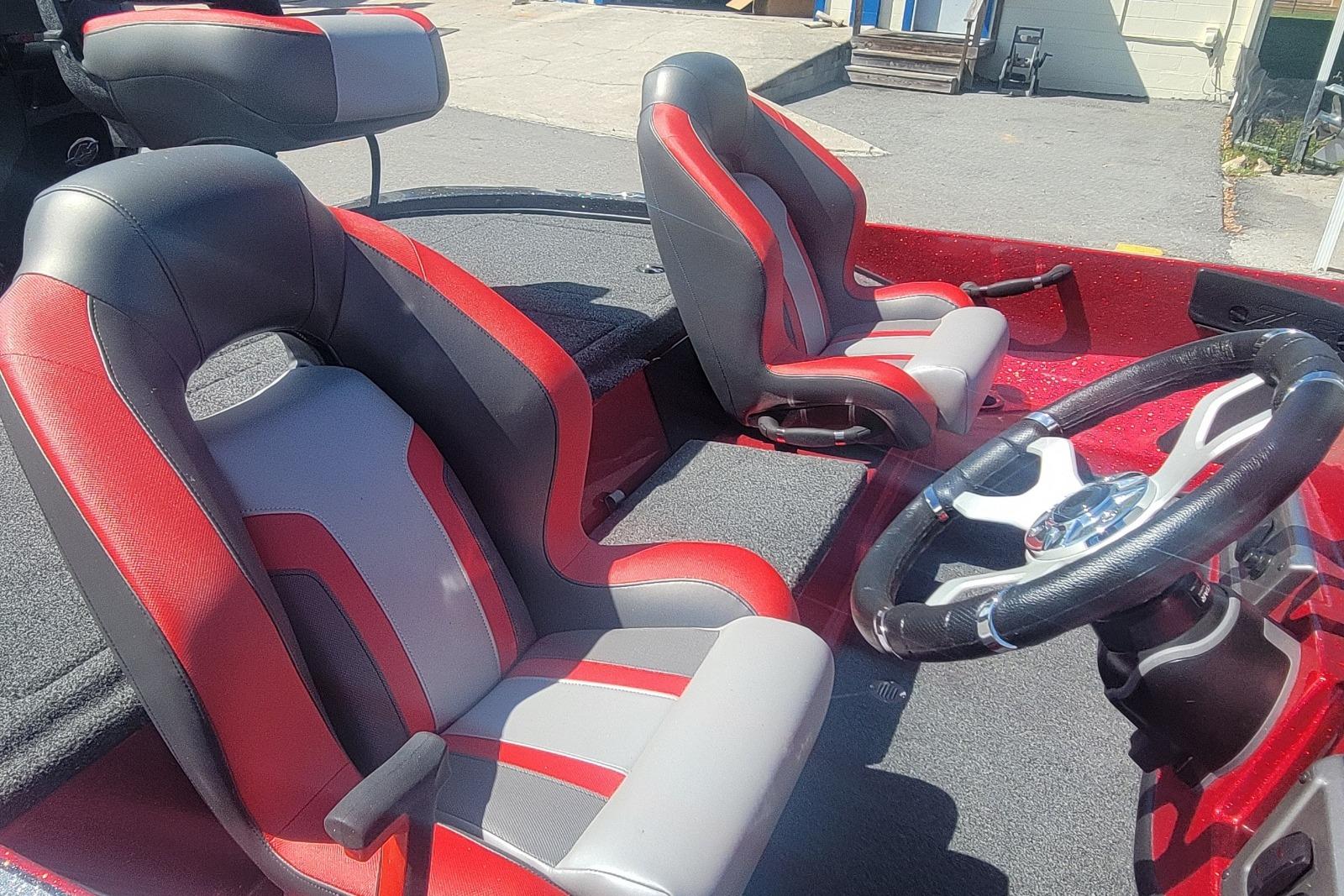 2026 Nitro Z18 boat interior with red and gray seats and steering wheel.