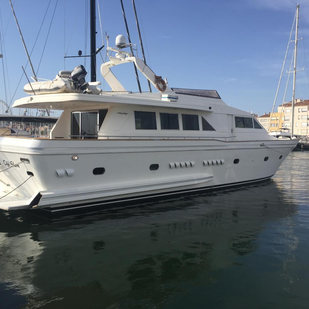 Luxury 1994 Falcon 76 yacht docked in a marina under clear blue skies.