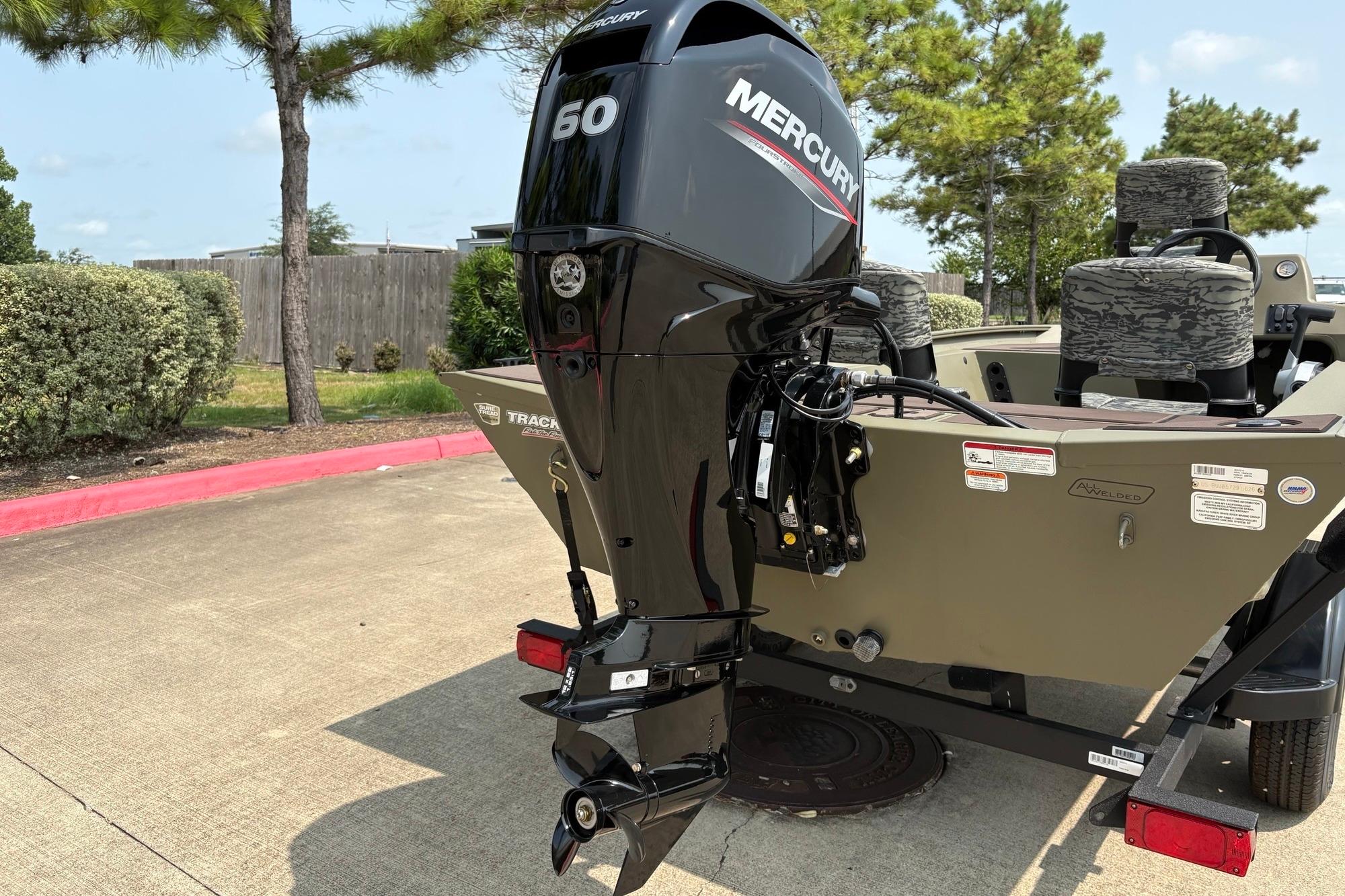 2026 Tracker Grizzly 1754 SC boat with Mercury 60 outboard motor in a parking area.
