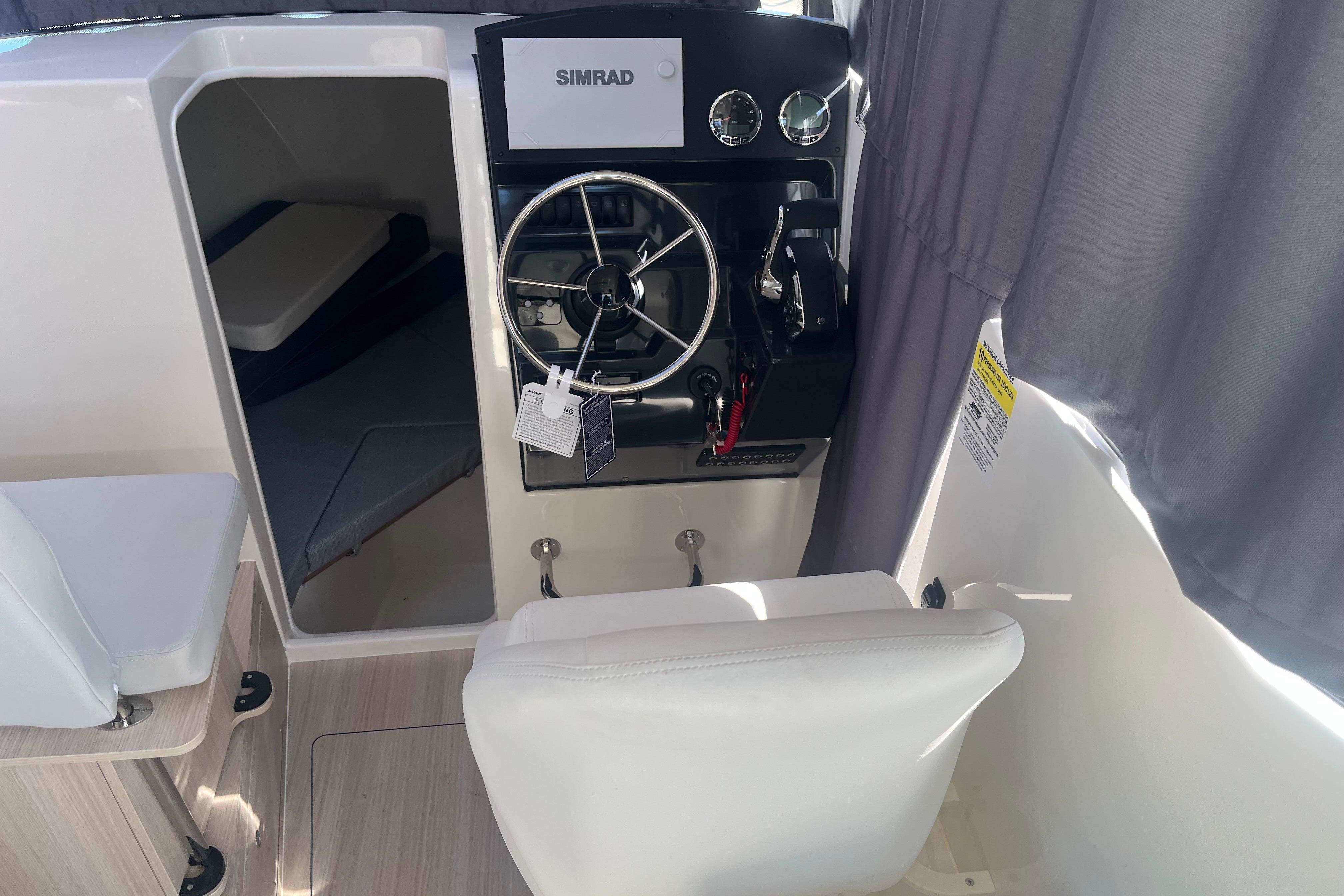 Interior view of 2025 Bayliner Trophy T25 Pilothouse with steering wheel and cabin.
