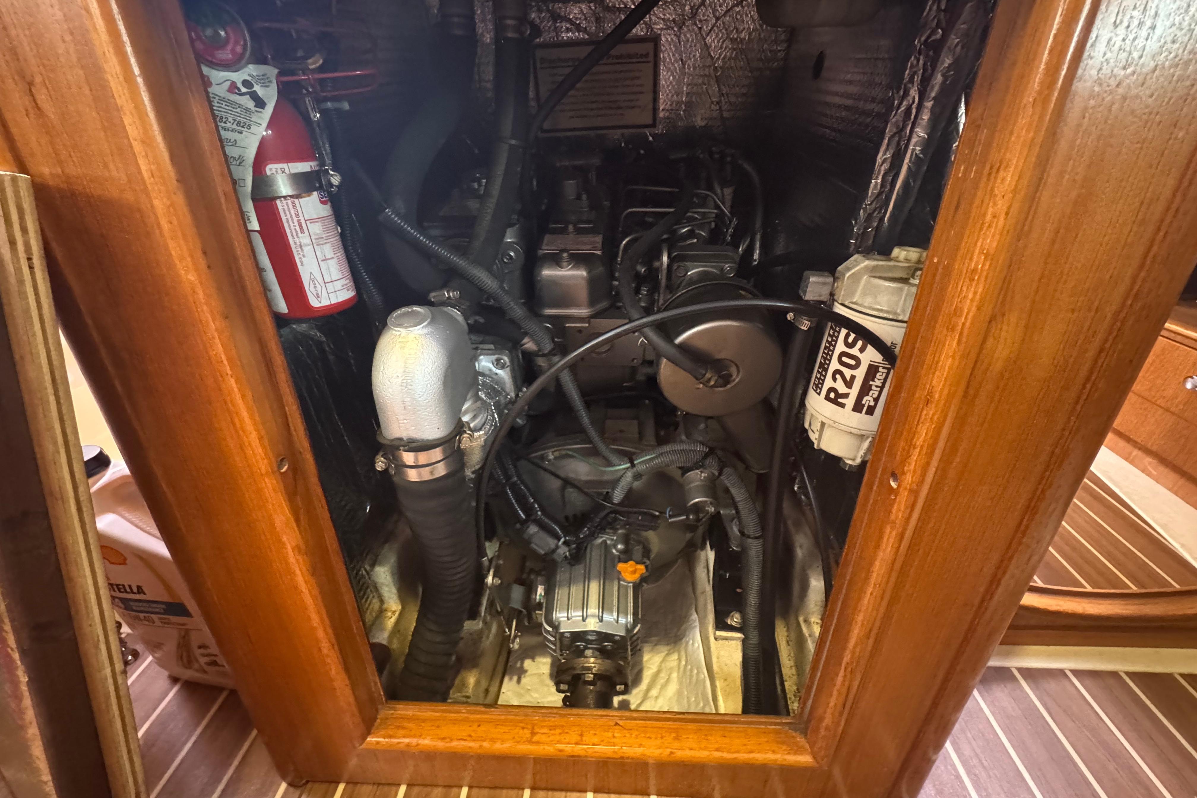 Engine compartment of a 2004 Hunter 386 sailboat, featuring mechanical components and a fire extinguisher.
