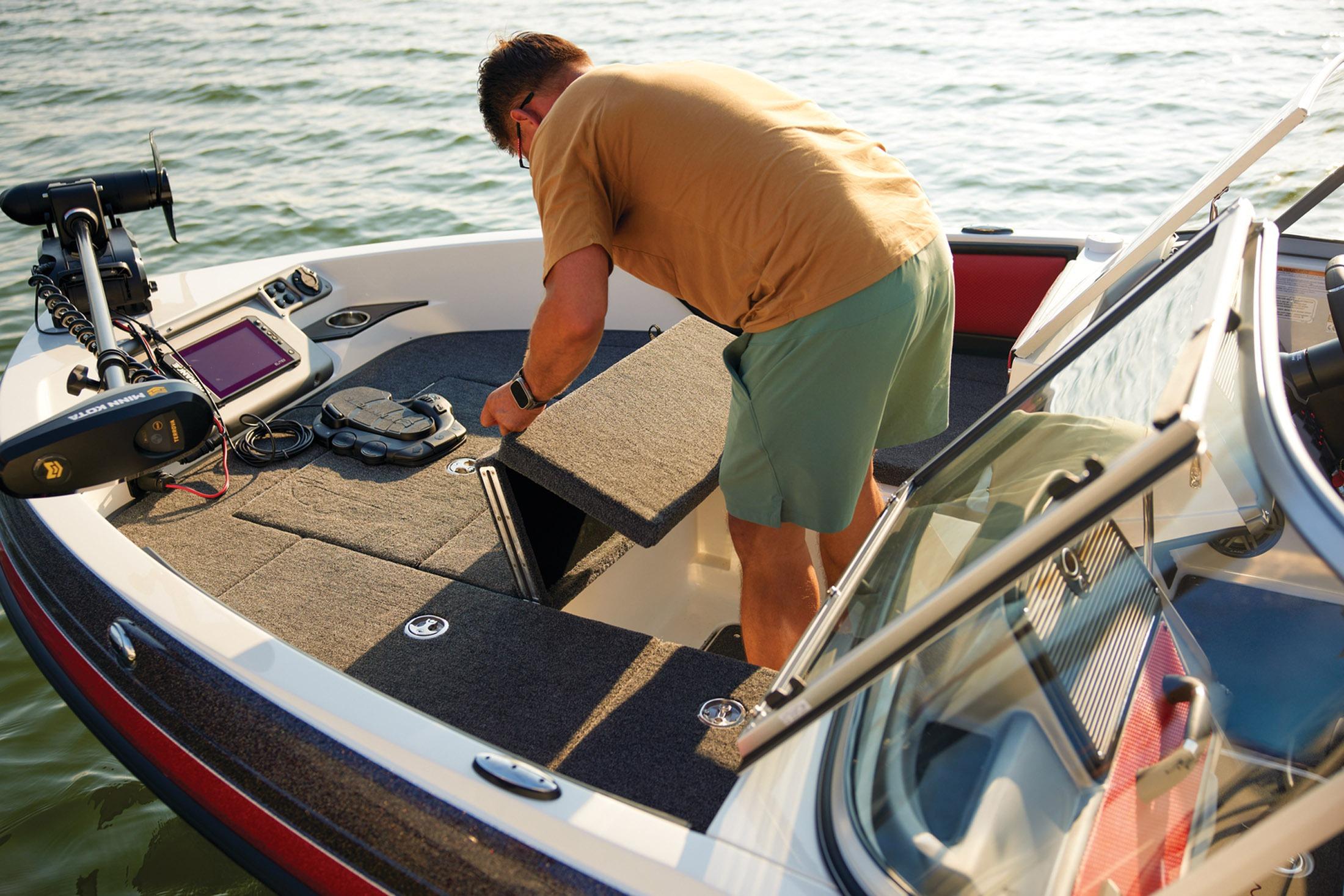 Man accessing storage on 2026 Ranger 1850MS boat, equipped with fishing gear.