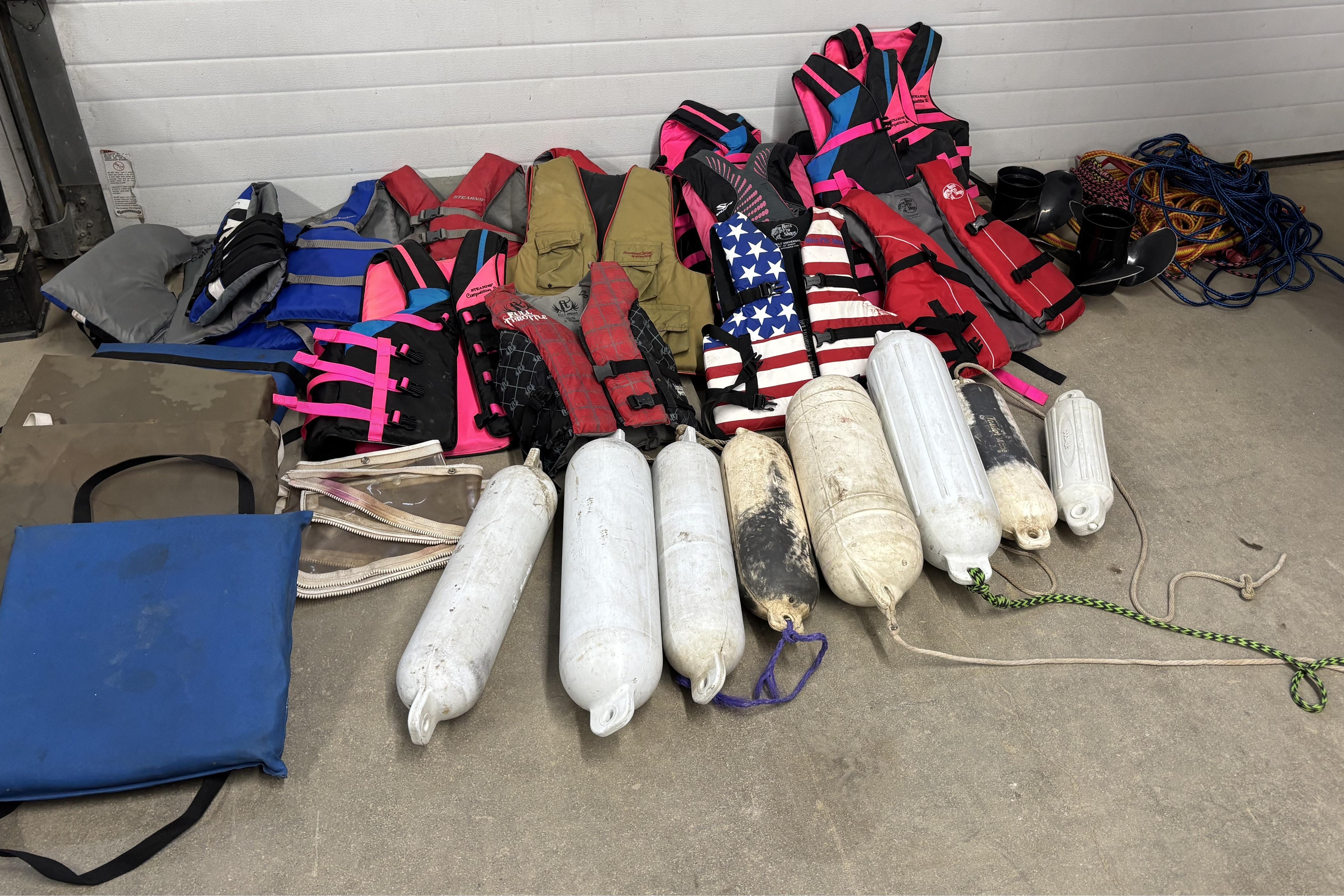 Assorted life jackets, boat fenders, and ropes for a 1993 Larson SEi 200 Cuddy I/O.