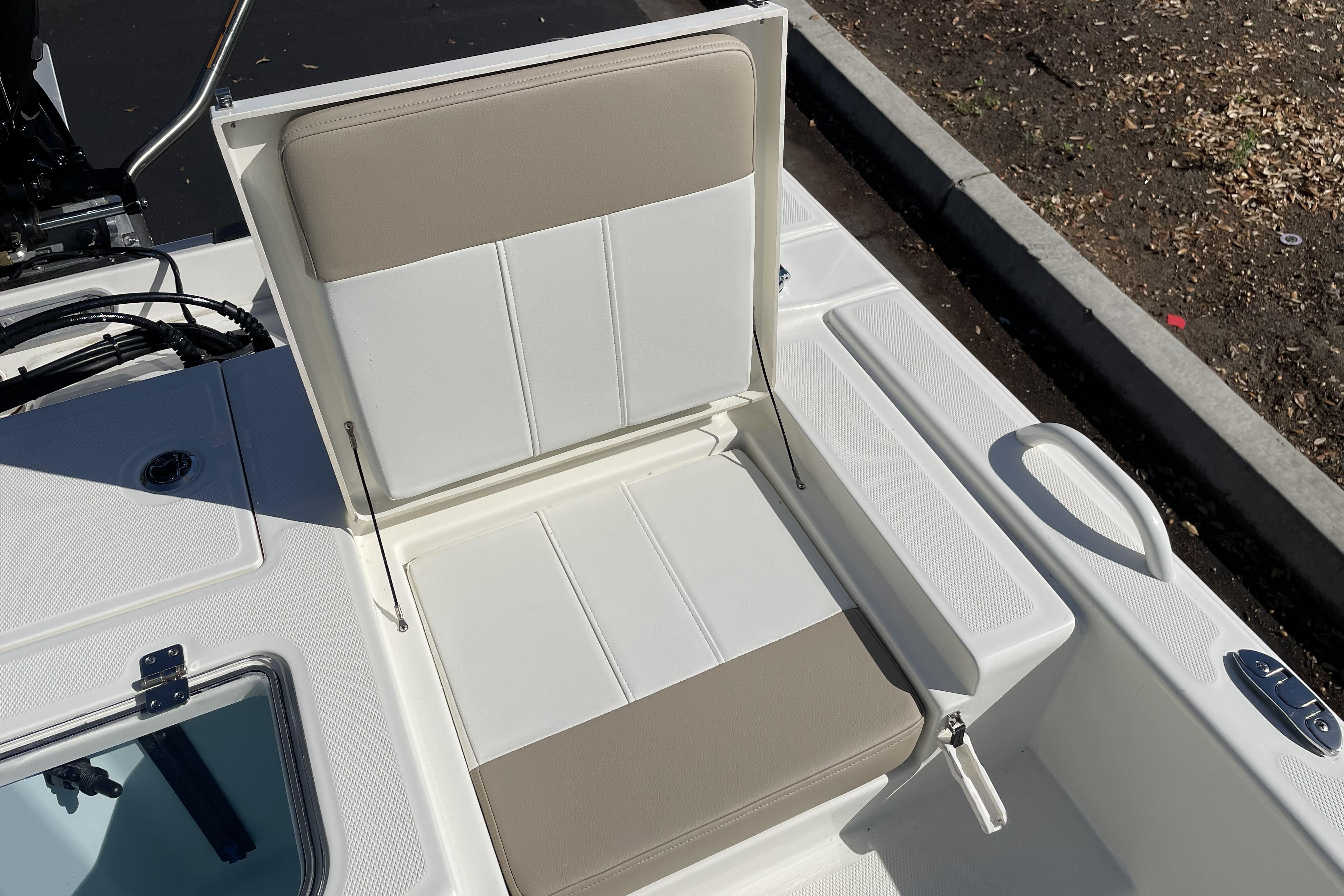 2026 Mako Pro Skiff 19 CC boat seat with storage compartment open.