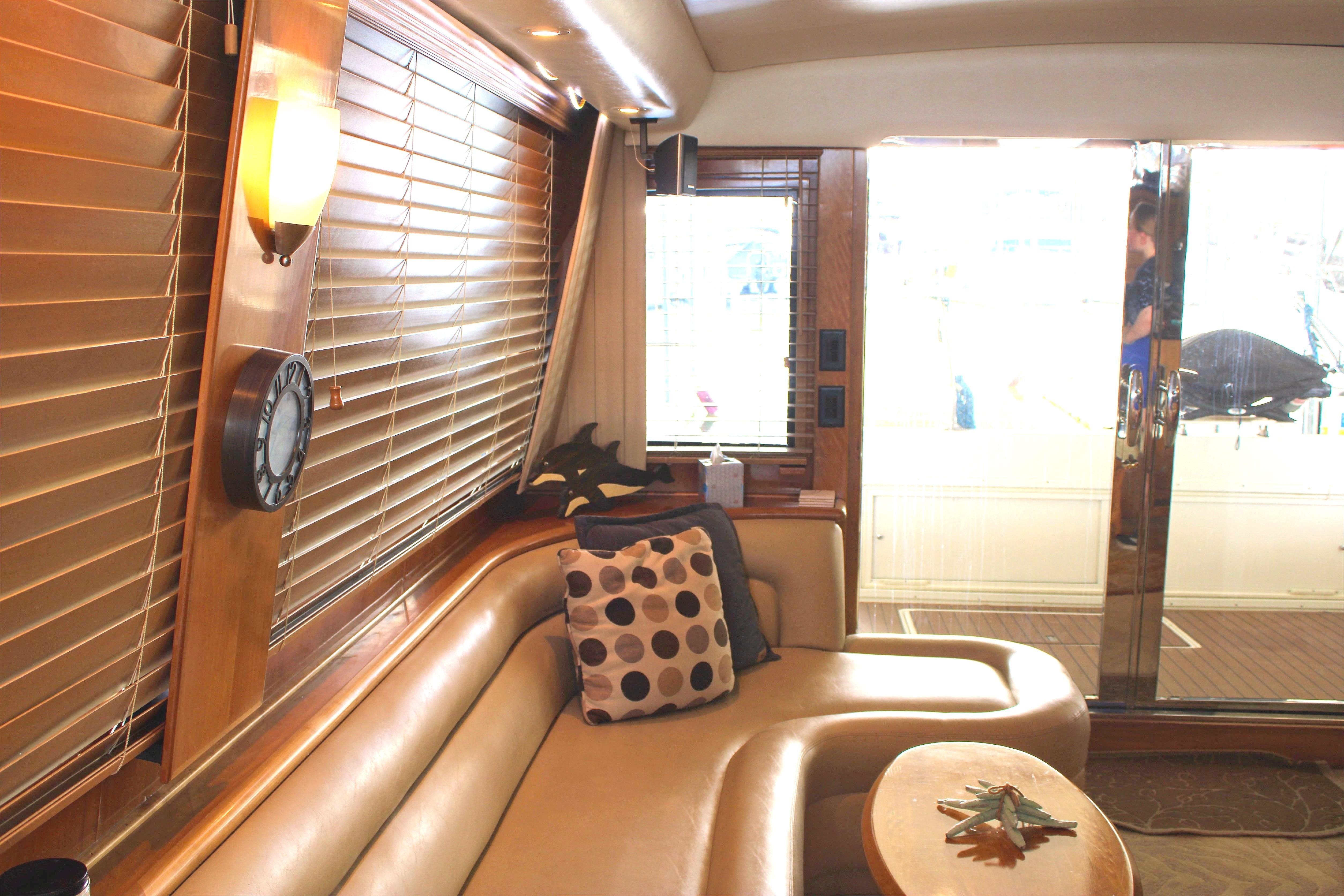 Luxurious interior of a 2007 Navigator 5100 yacht with leather seating and large windows.