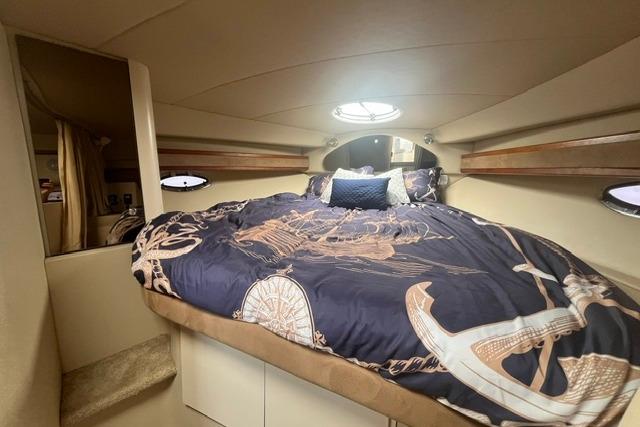 Interior cabin of 2004 Cruisers Yachts 3372 Express with nautical-themed bedding.