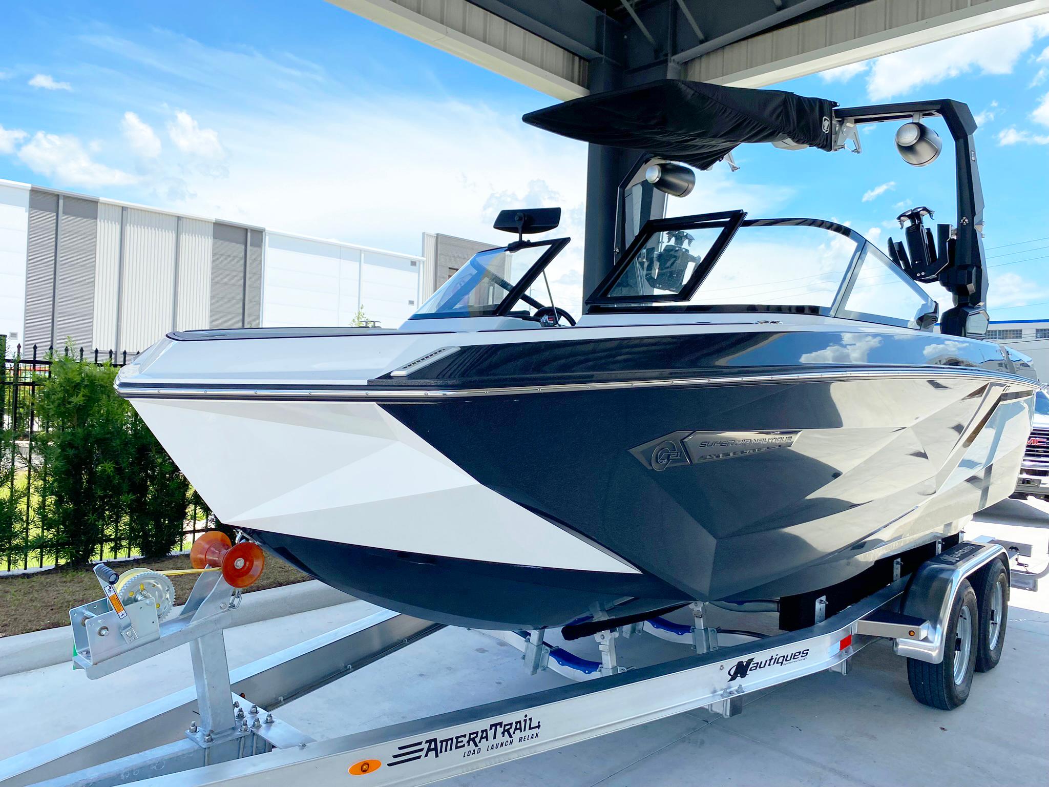 2024 Nautique Super Air Nautique G21 boat on trailer, under a canopy.