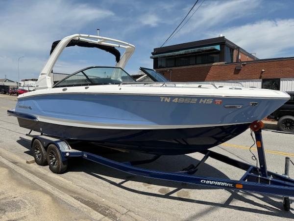2023 Chaparral 267 SSX boat on trailer, parked on street, sunny day.
