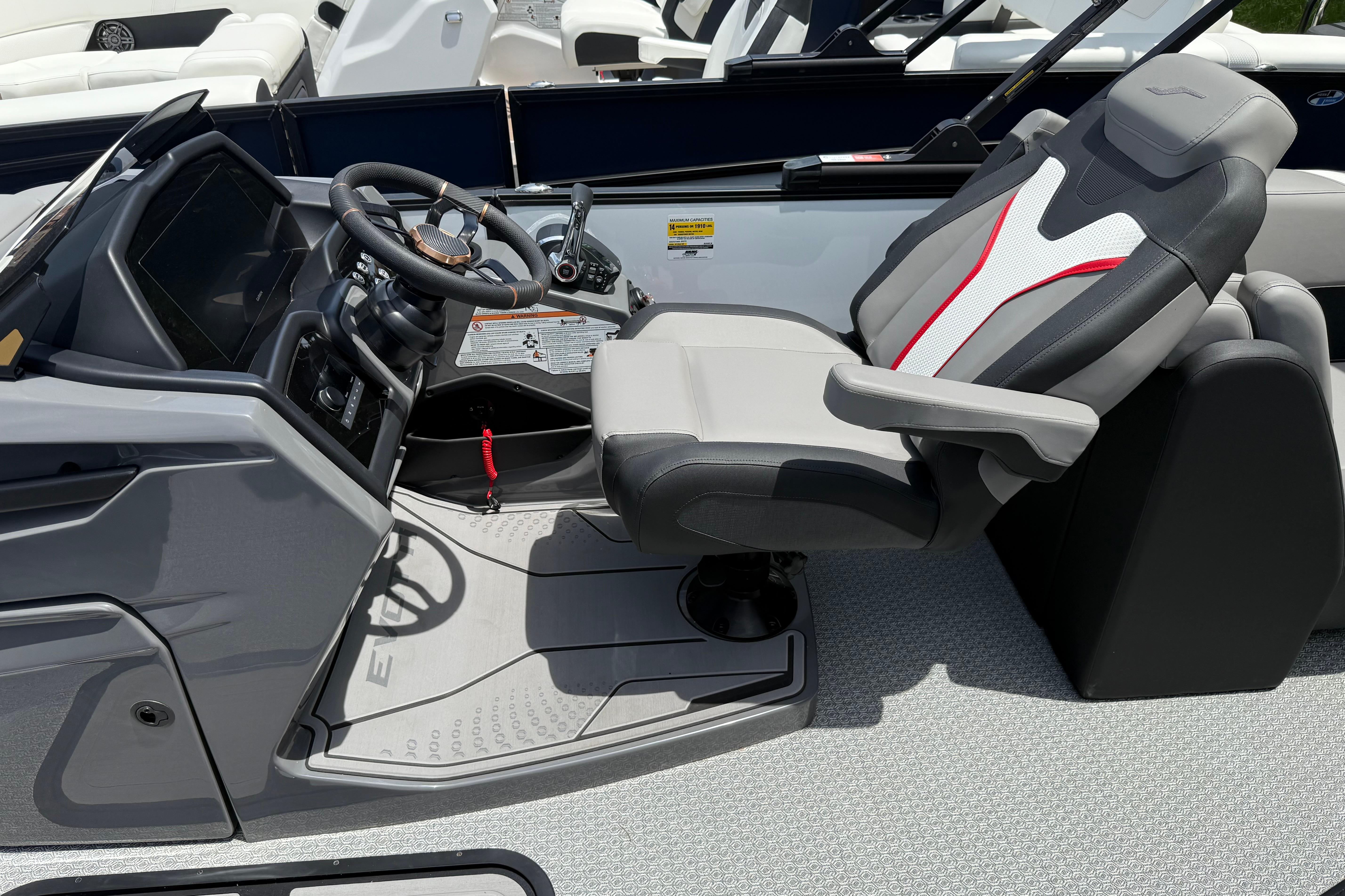 Captain's seat and helm of 2026 Evotti 723QL boat, featuring modern controls and design.