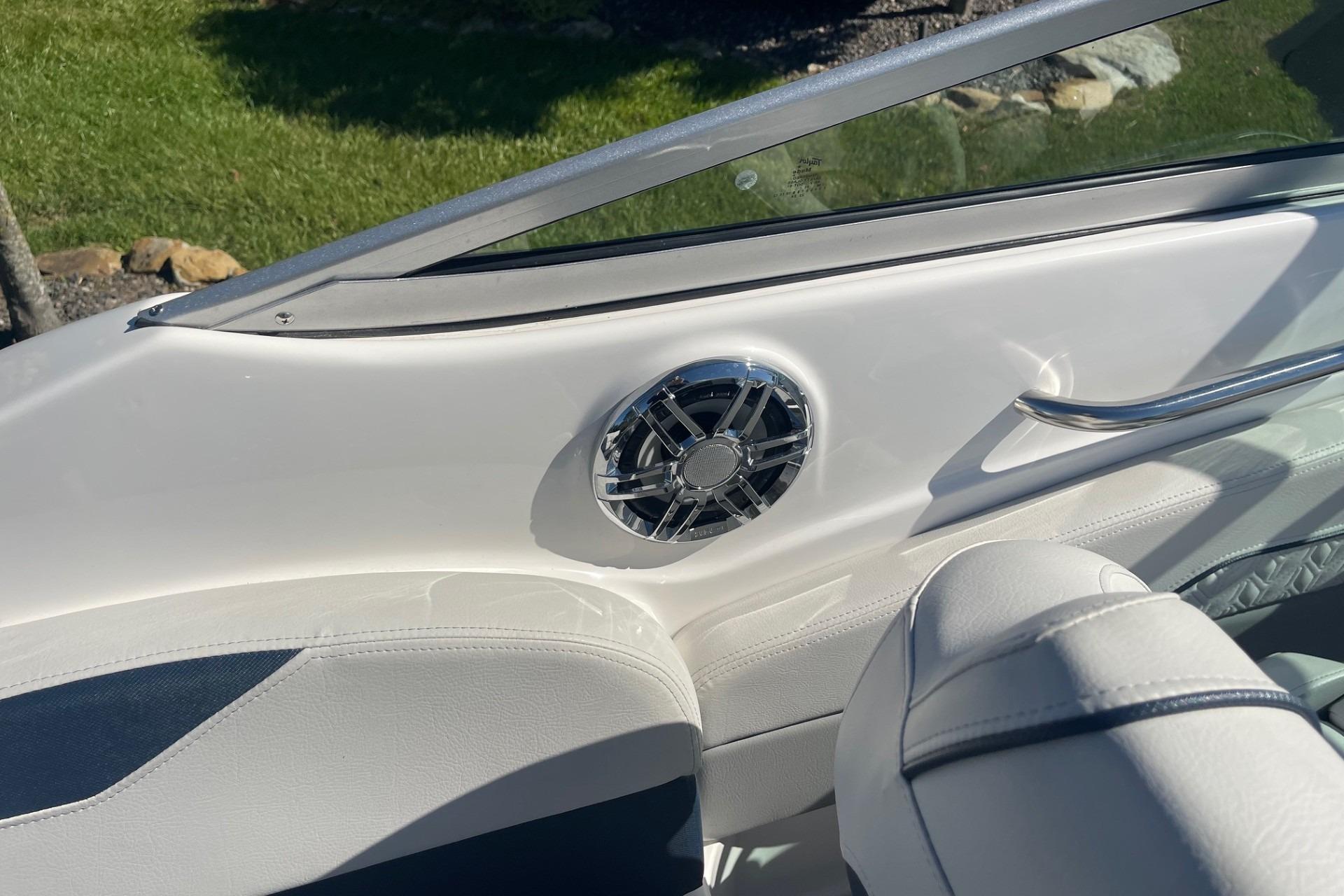 Interior of 2023 Hurricane SunDeck 2400 OB boat with speaker and seating.