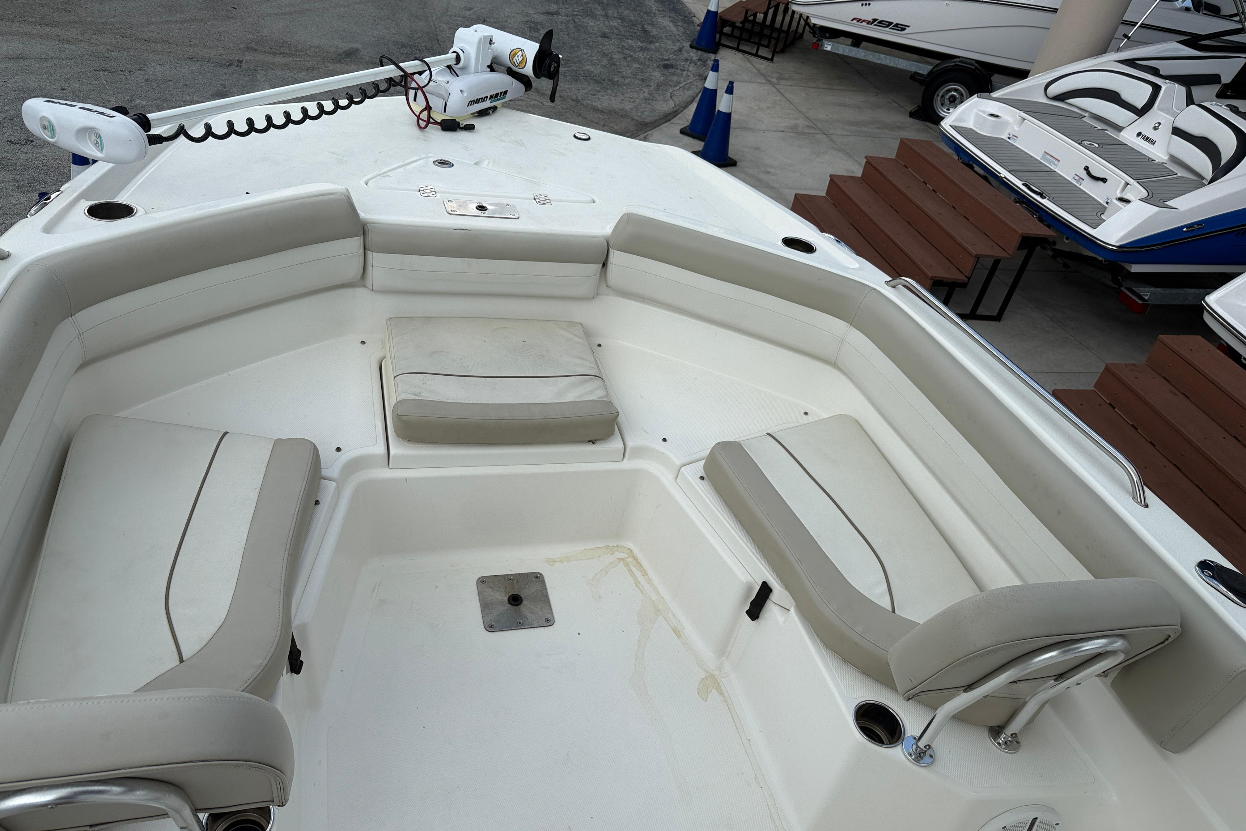 Interior view of a 2015 NauticStar 231 Coastal boat, featuring cushioned seating and a trolling motor.