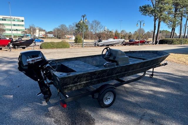 2026 Tracker Grizzly 1648 SC boat with Mercury engine on trailer, parked outdoors.