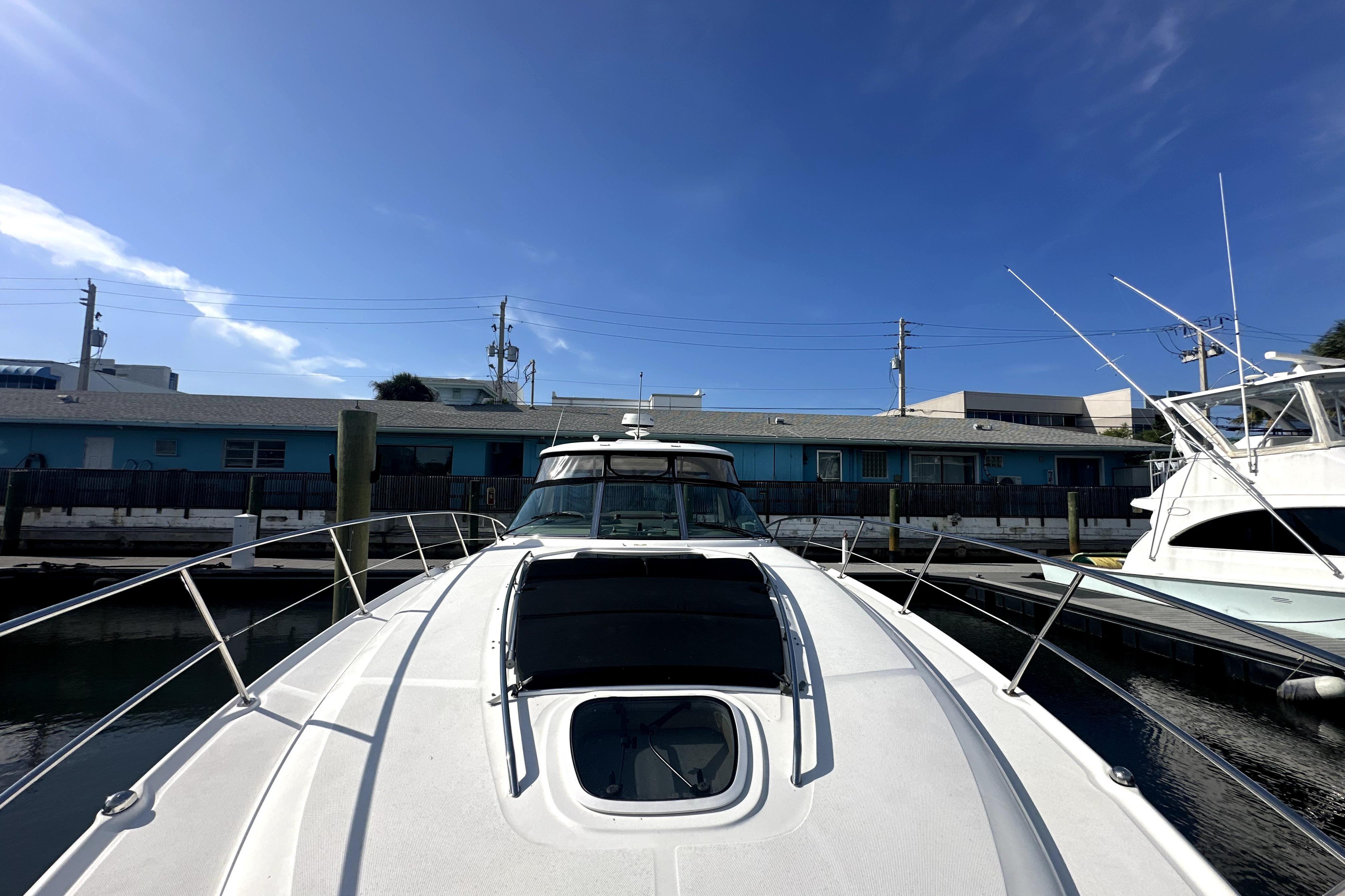 2007 Sea Ray 44 Sundancer yacht docked at marina under clear blue sky.