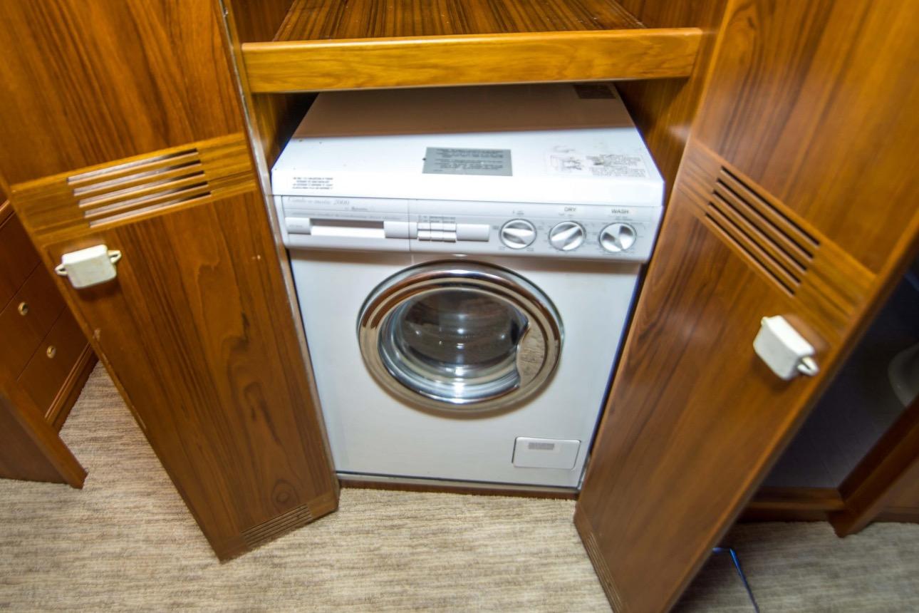 Washing machine in wooden cabinet on 2000 Riviera 48 Enclosed Flybridge yacht.