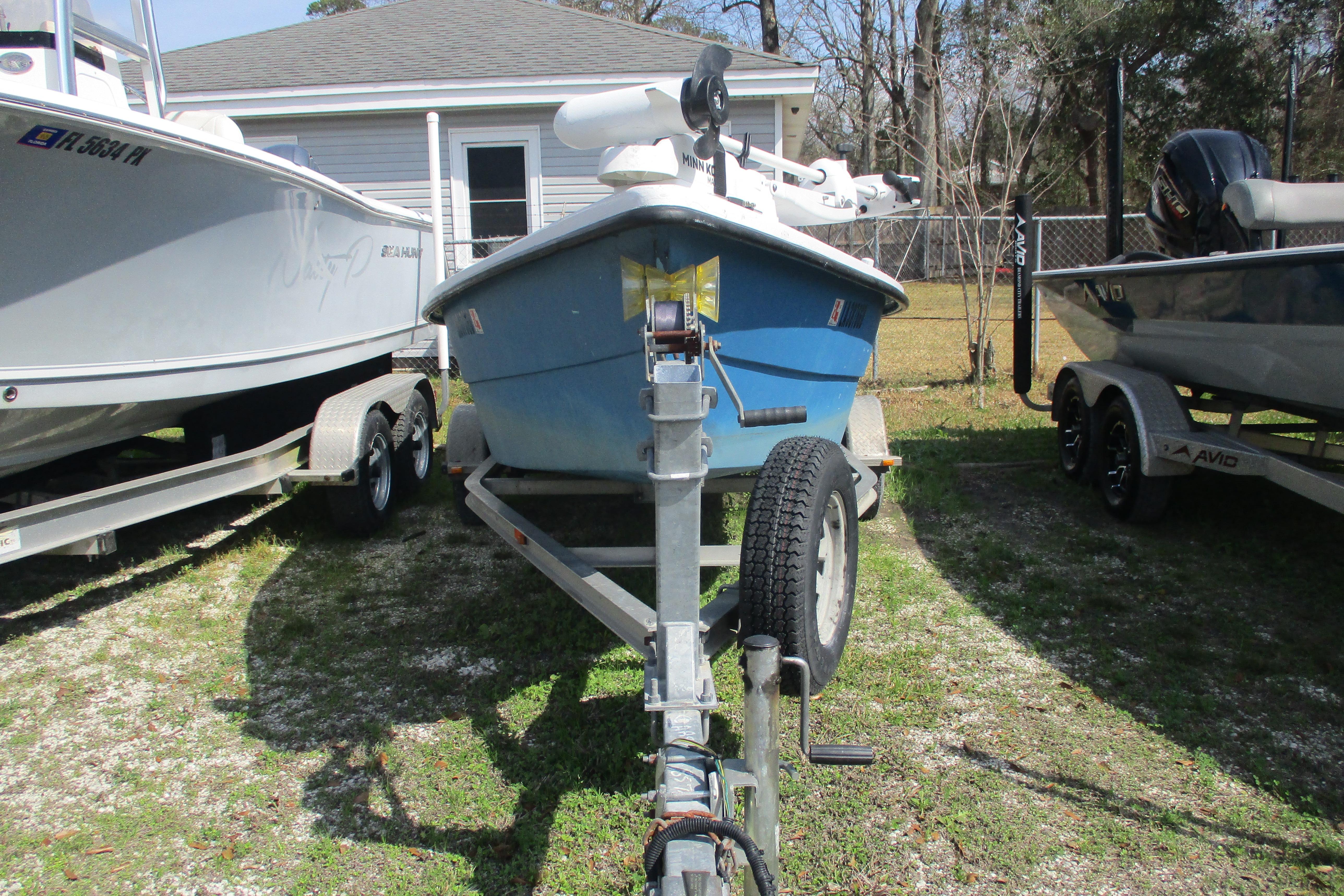 2012 Stumpknocker 17 SPORT boat on trailer, parked between two other boats.