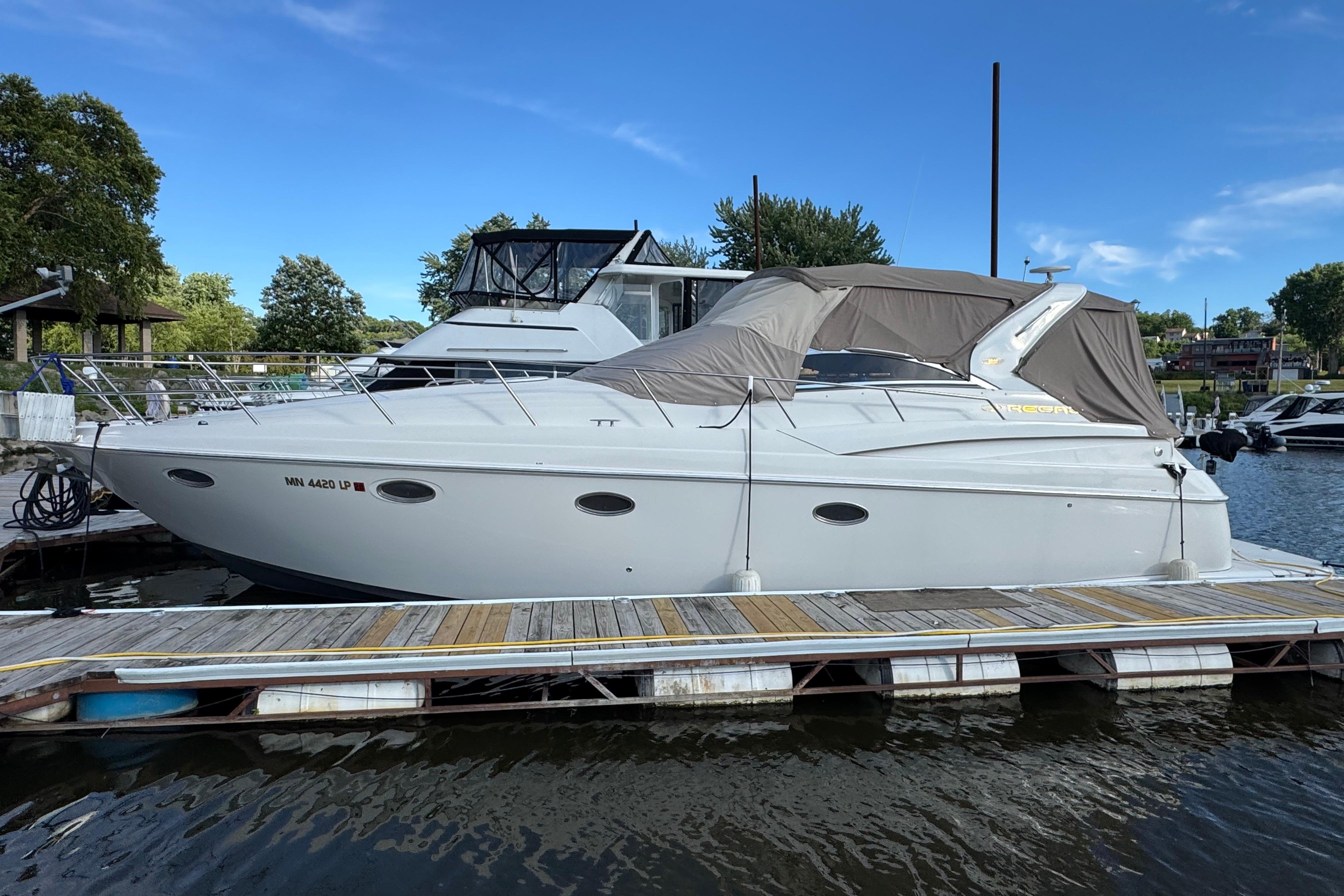 2007 Regal Commodore 3860 yacht docked at marina under clear blue sky.