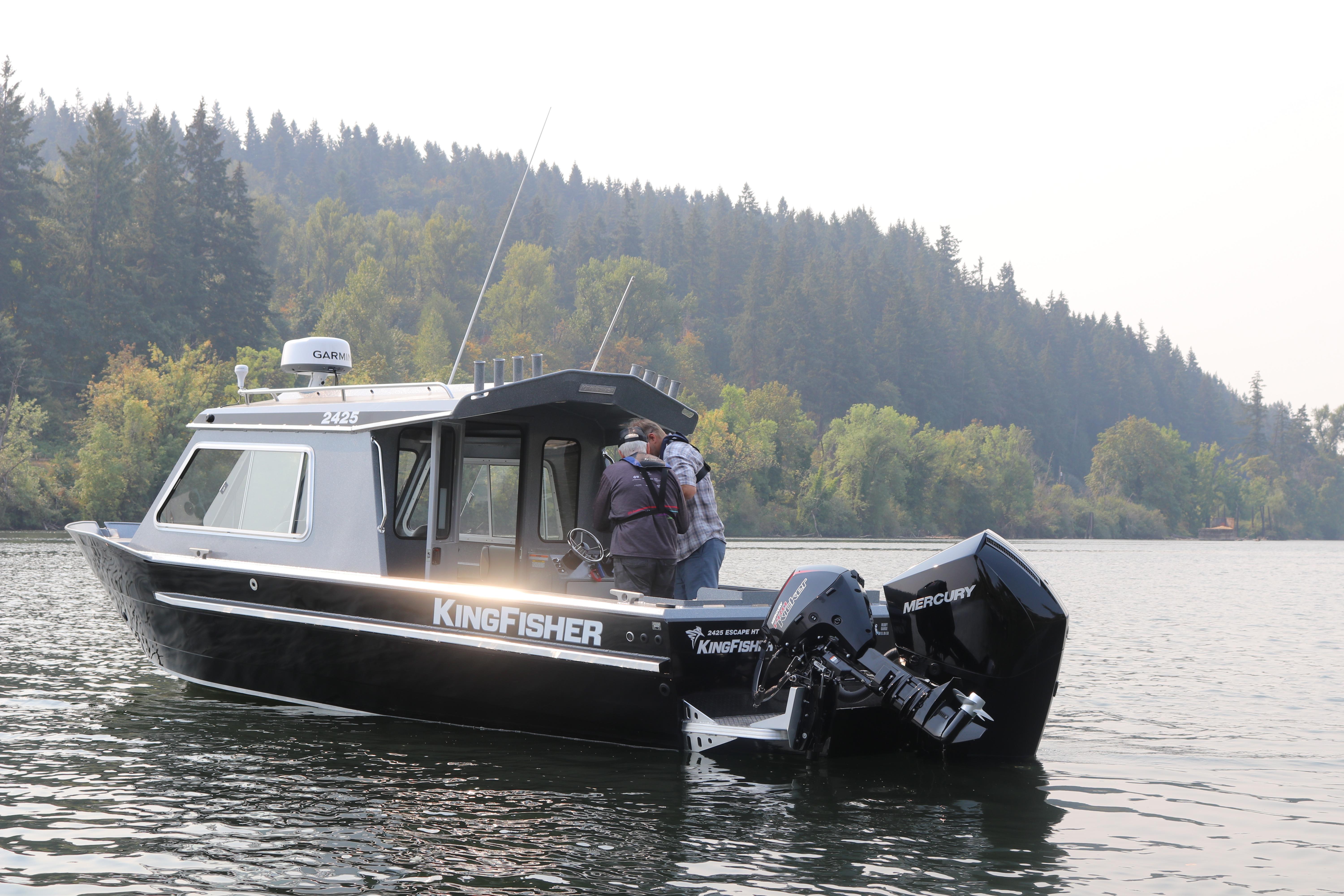 2026 KingFisher 2425 Escape HT boat on a serene lake with forested background.