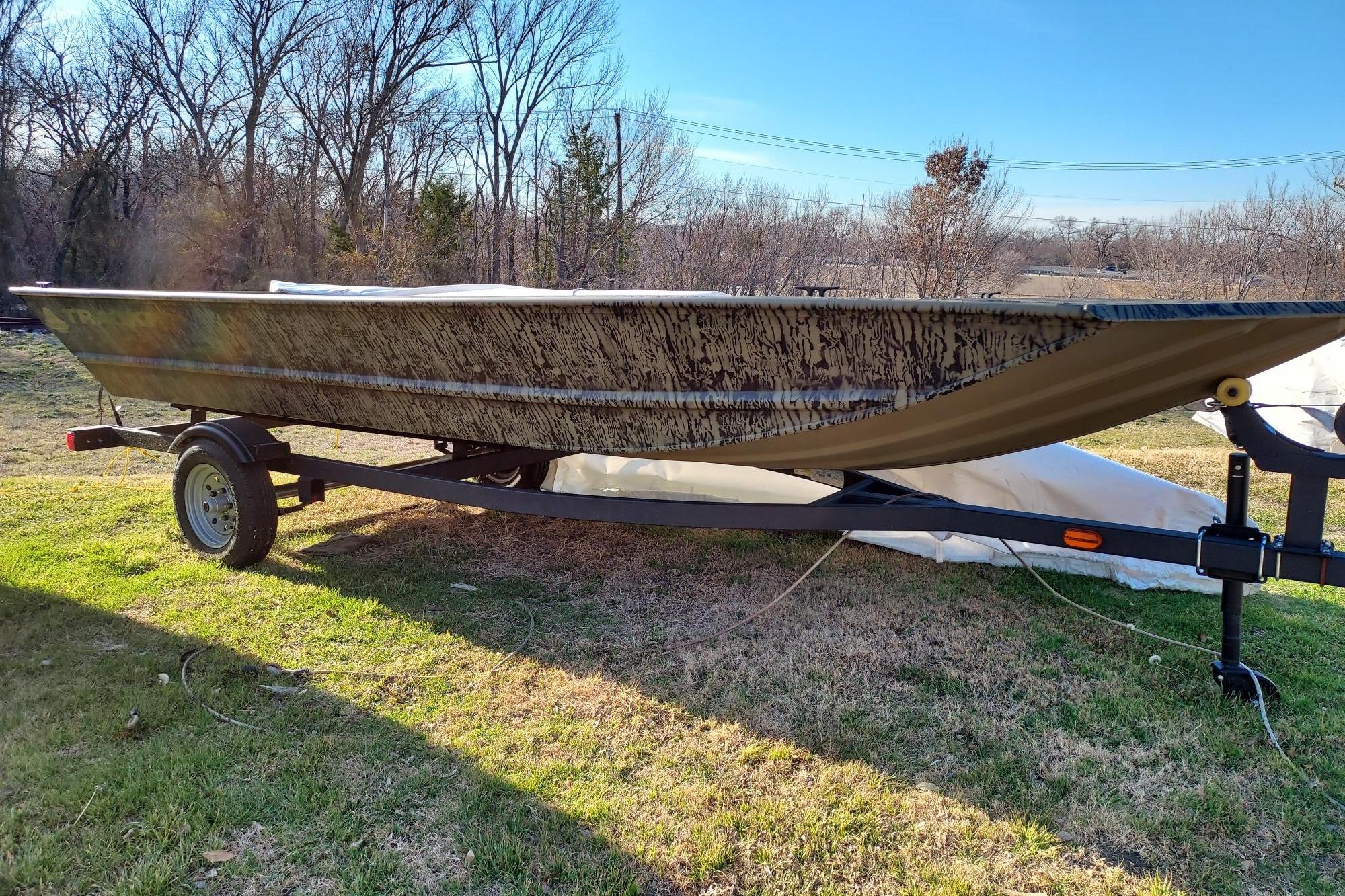 2026 Tracker Grizzly 1648 Utility boat on trailer, parked on grass.