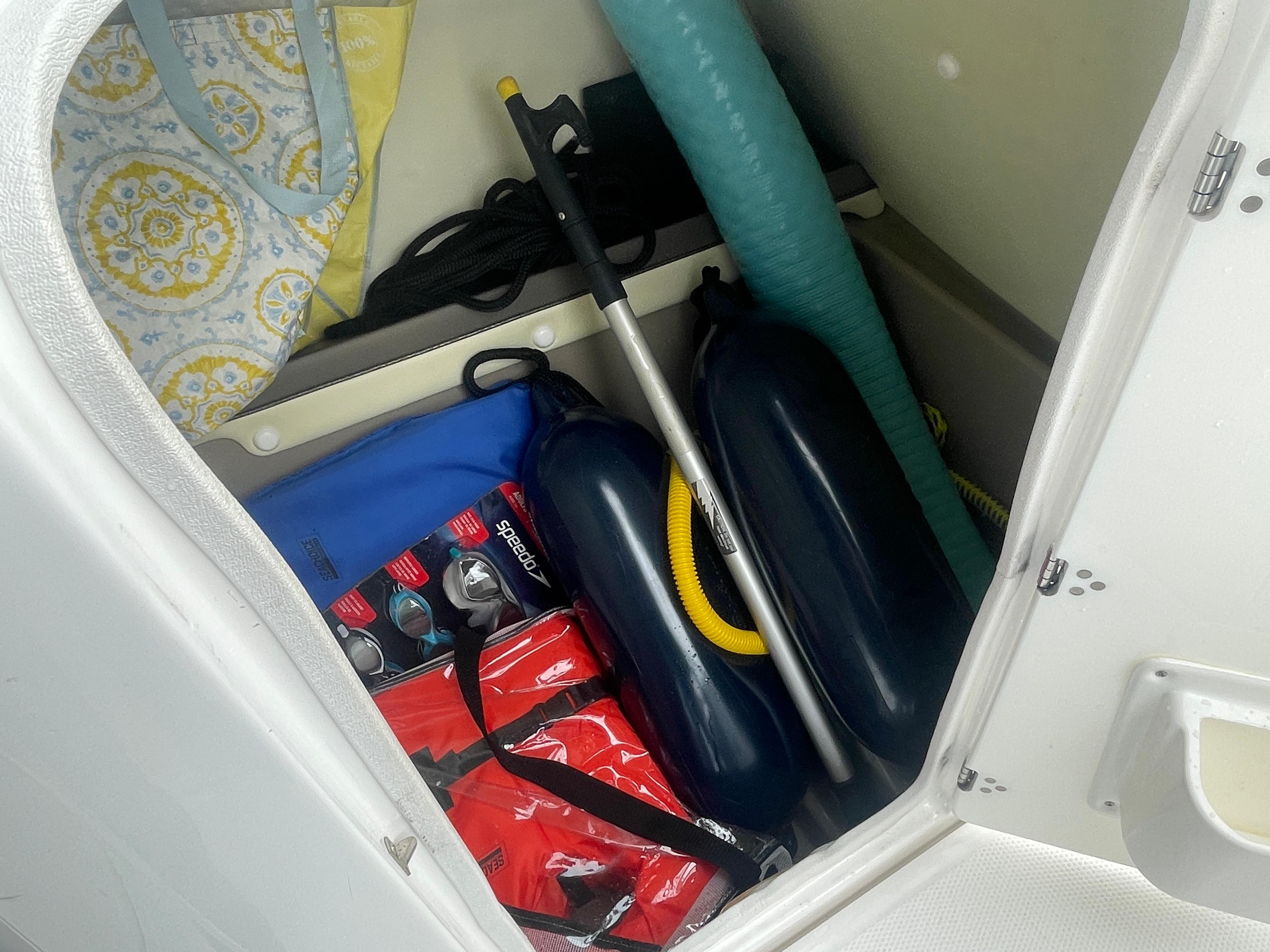 Storage compartment in 2020 Yamaha Boats 242 Limited S with boating accessories.