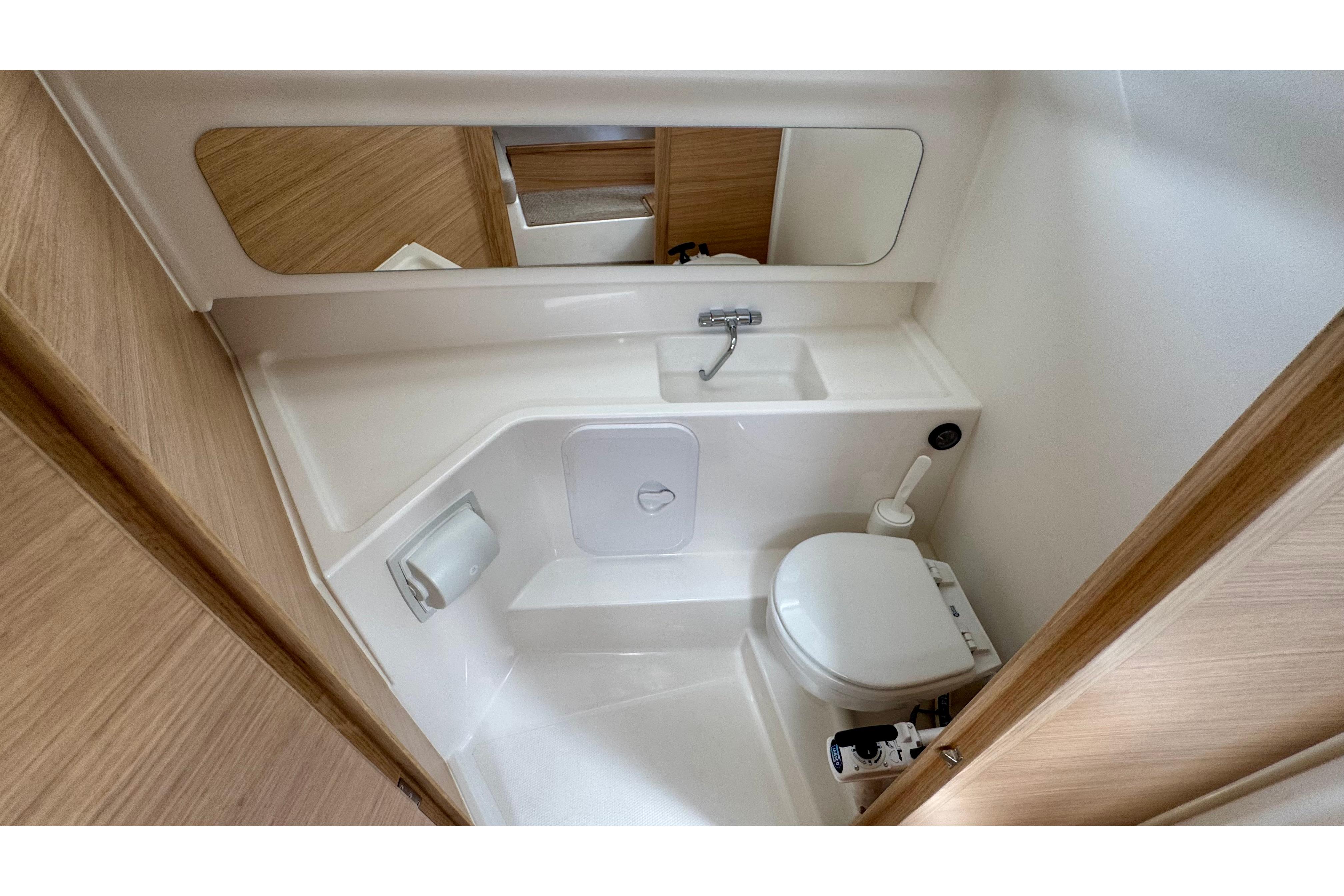 Interior view of a modern boat bathroom with sink and mirror.