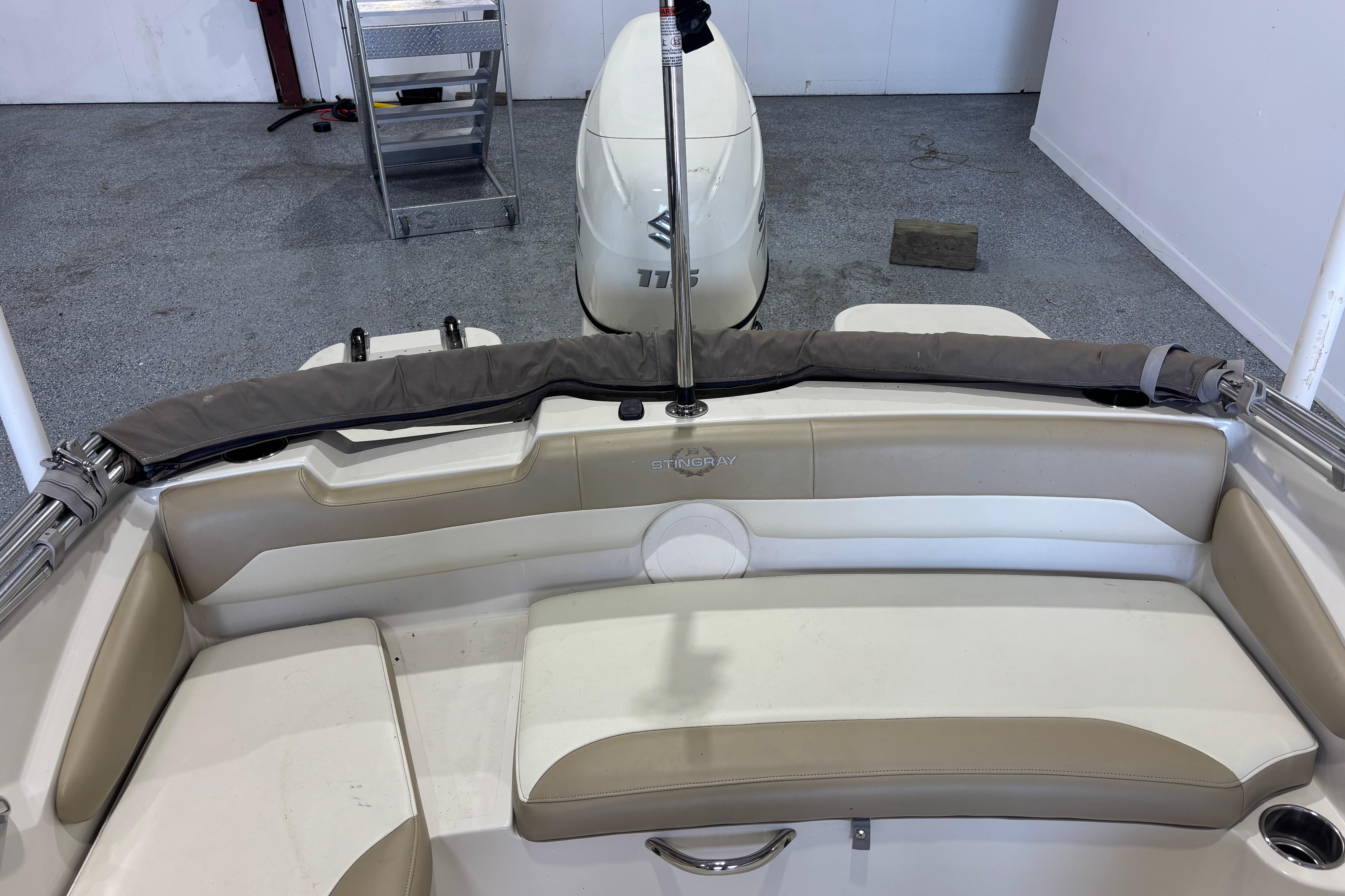 2017 Stingray 182 SC boat interior with seating and motor, in a garage setting.
