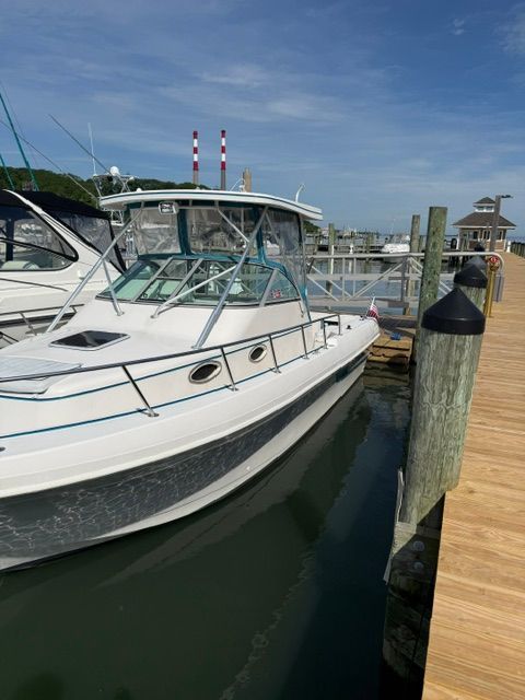 A 1995 Pro-Line 2950 Walkaround docked at a wooden pier in a marina.