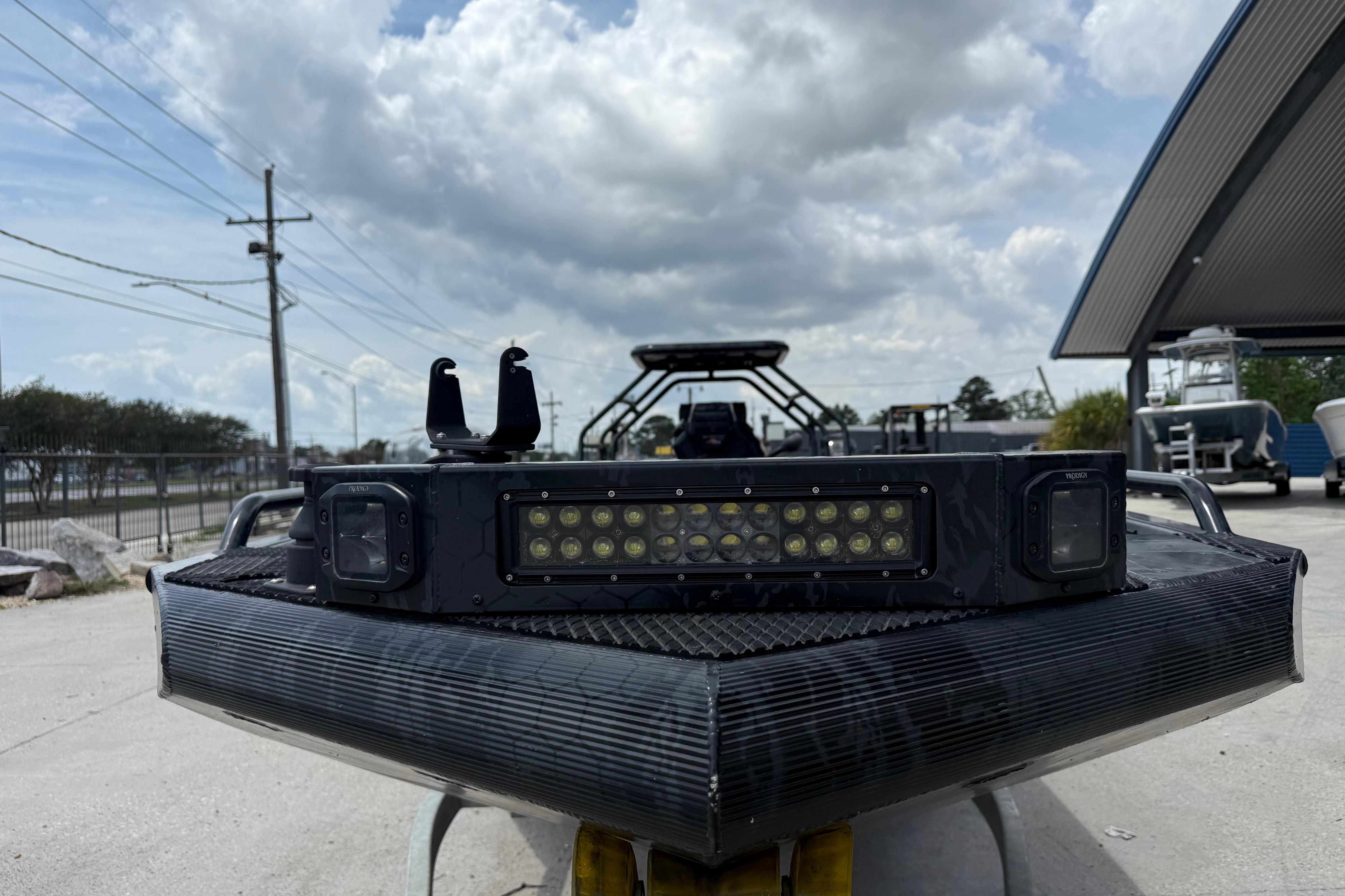 Front view of 2024 Prodigy 17 boat with LED light bar under cloudy sky.