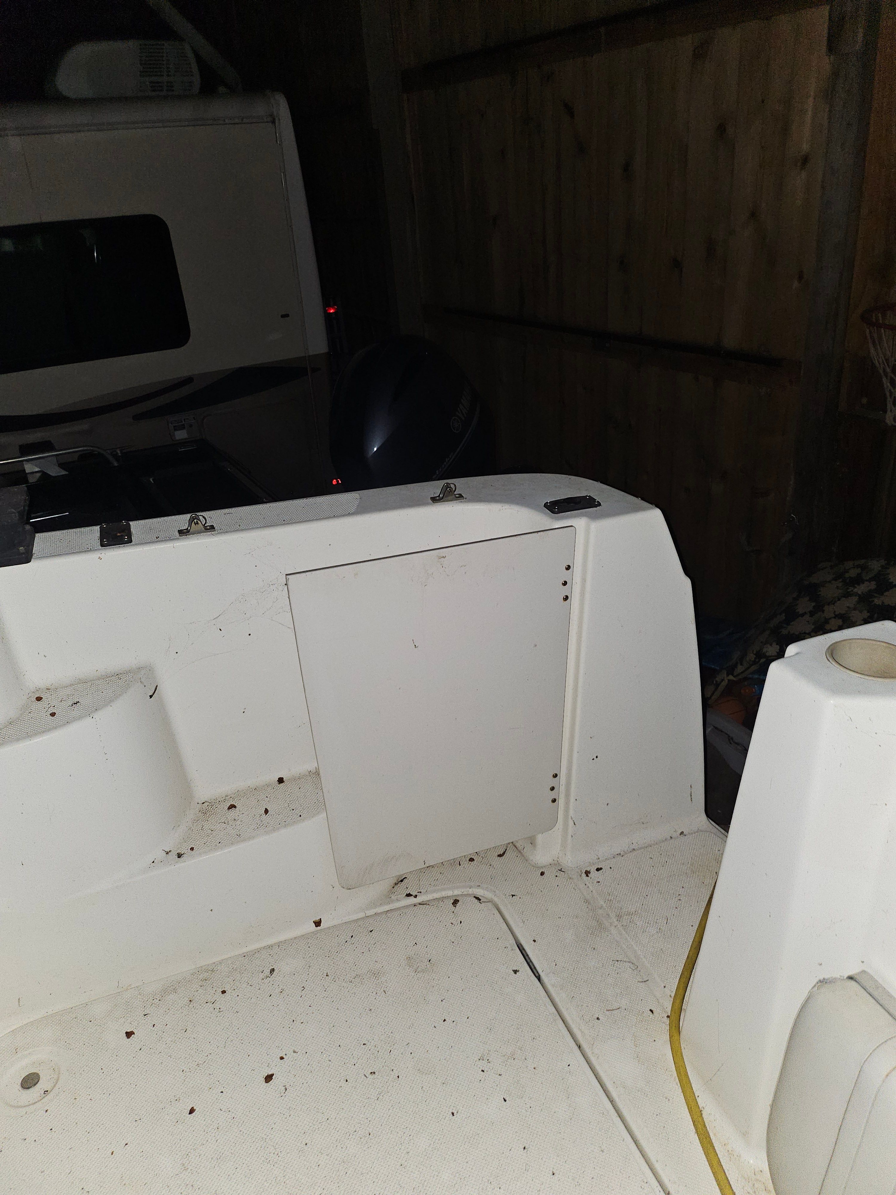 The image shows the stern of a Bayliner 242 Ceara boat in a garage.