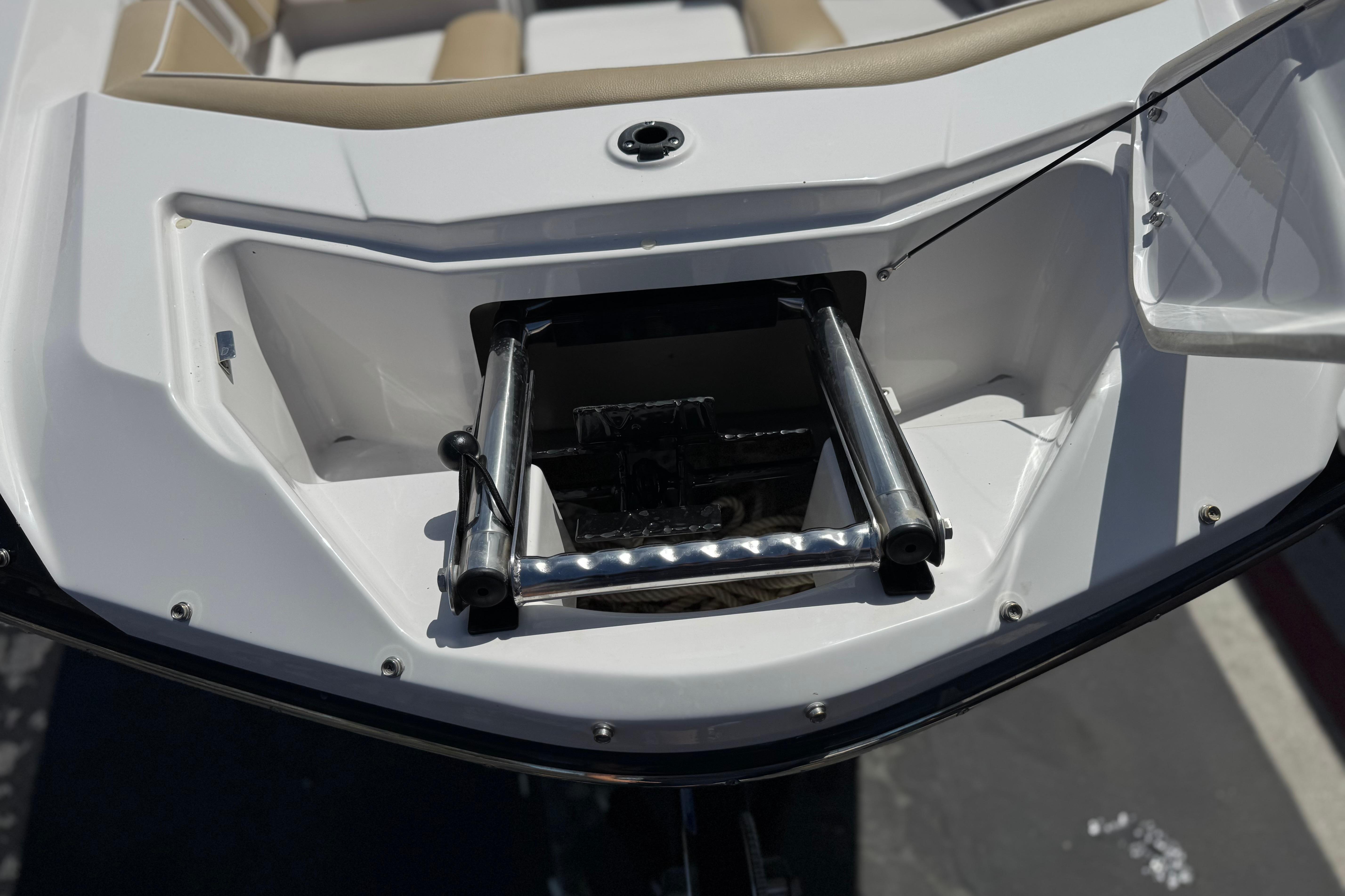 2017 Scarab 255 H.O. Platinum boat with retractable ladder in open compartment.