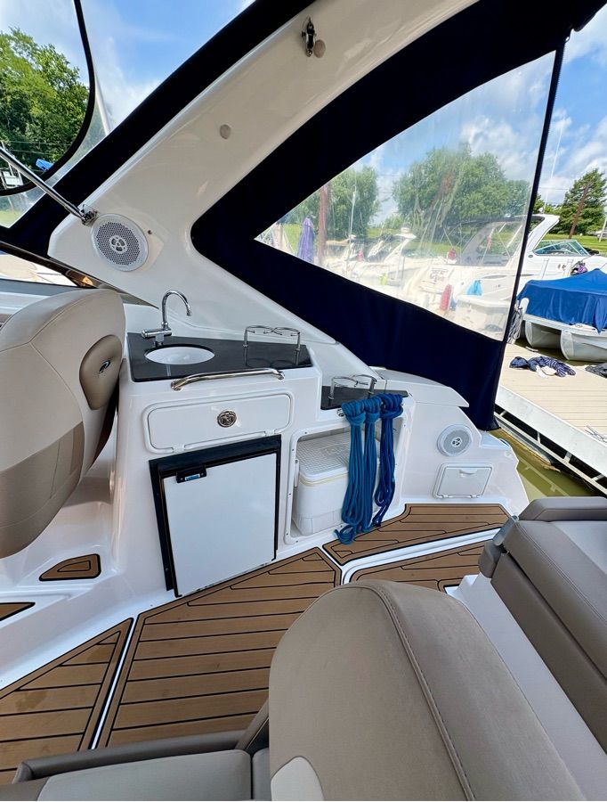 The image shows the cockpit of a 2014 Regal 30 Express with seating and a small kitchenette.