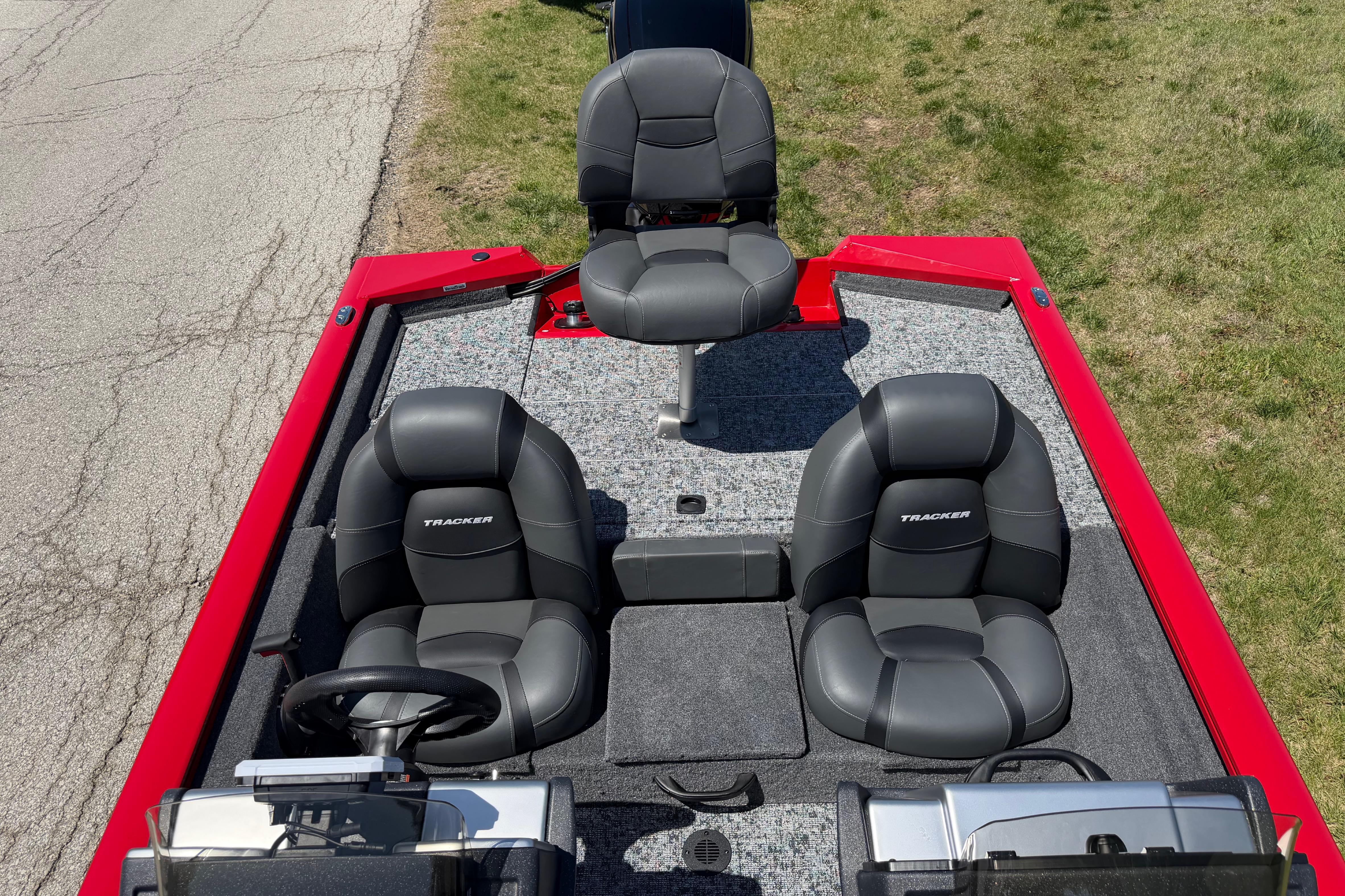2026 Tracker Pro Team 175 boat interior with three gray seats on a red deck.