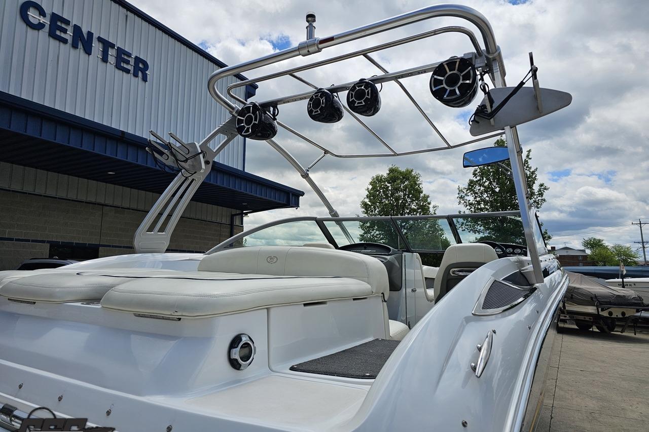 2010 Cobalt 232 WSS boat with wakeboard tower and speakers, parked near a center.