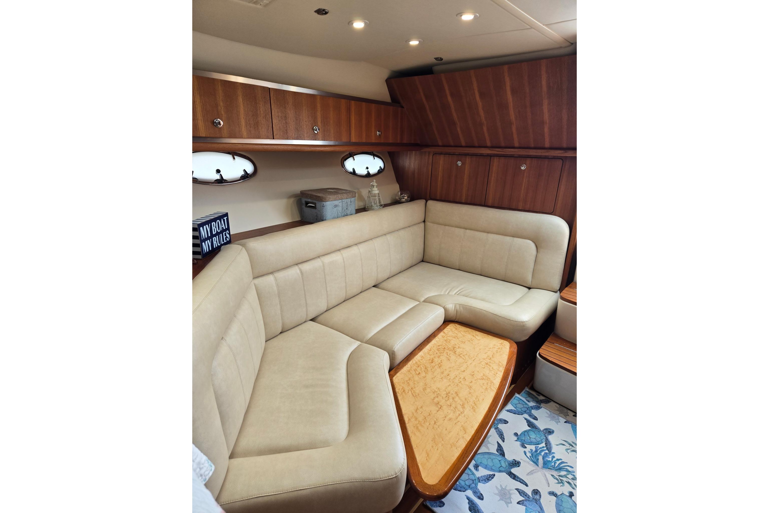 Luxurious interior of 2006 Tiara Yachts 3200 Open with plush seating and wooden accents.