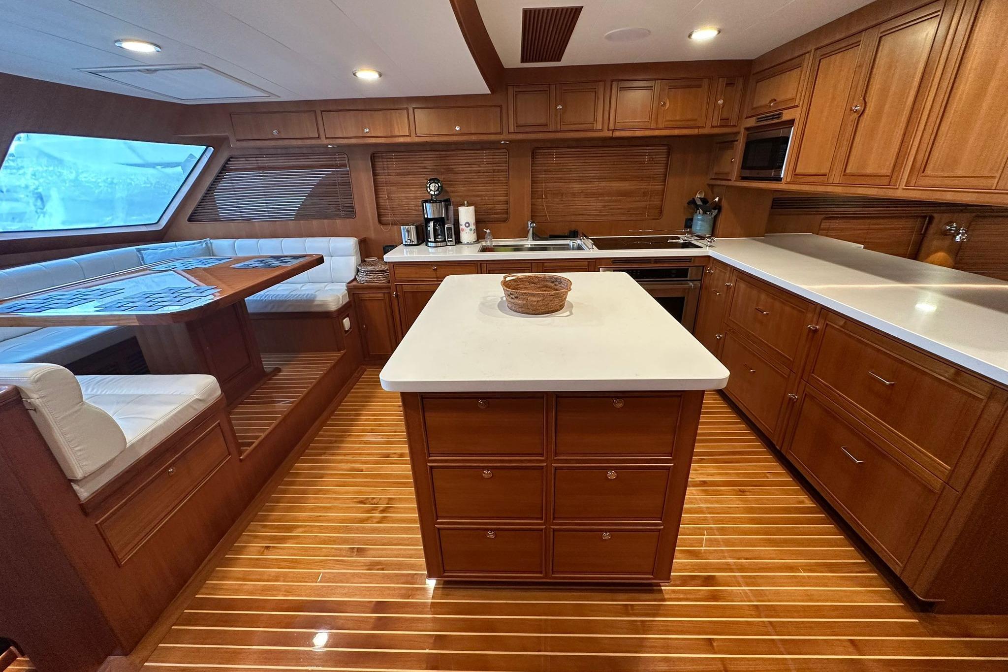 Luxurious 2023 Marlow Explorer 66E-CB yacht kitchen with wood cabinetry and modern amenities.