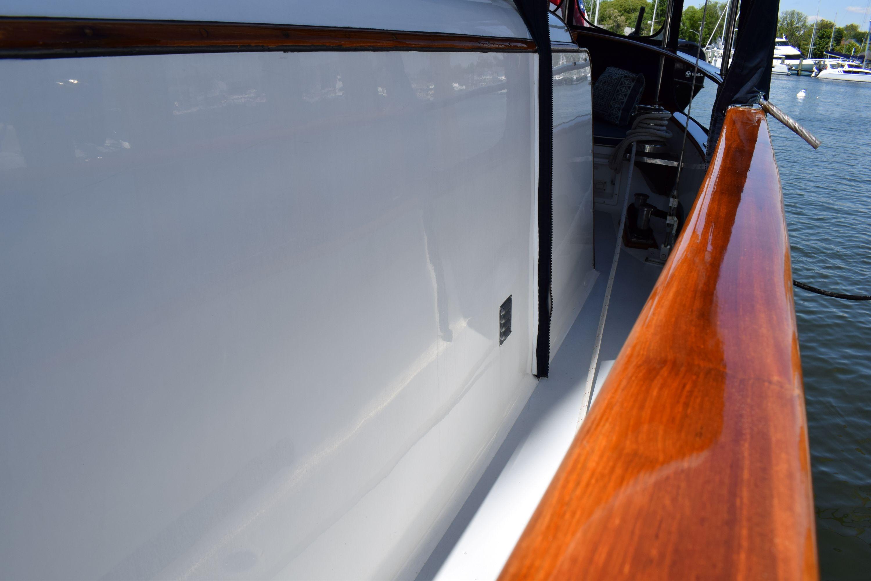 1980 Cheoy Lee 52 Motorsailer with polished wood railing and sleek white hull.
