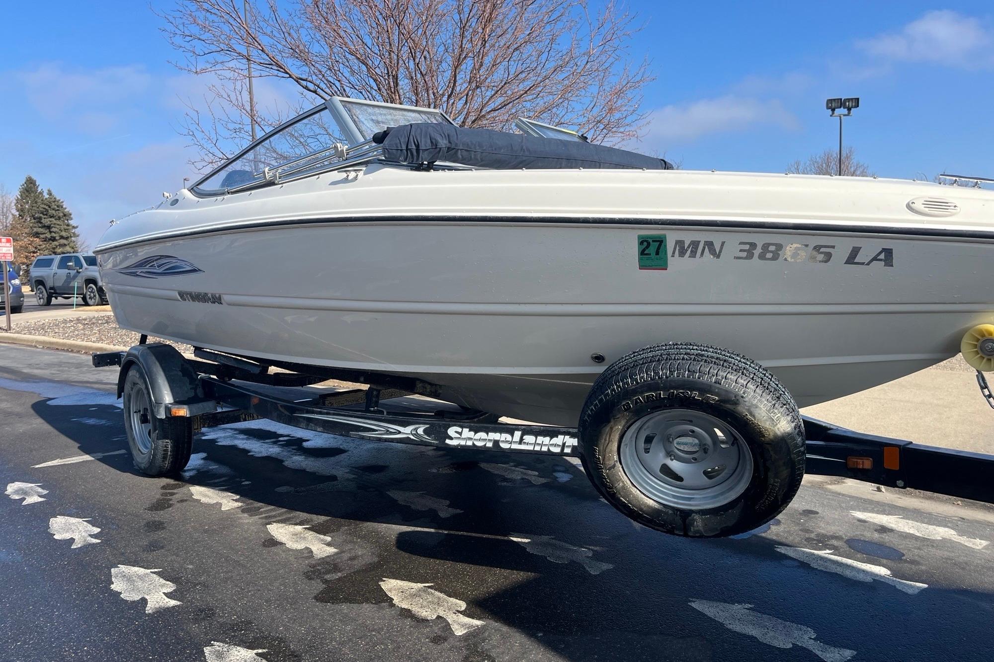 2013 Stingray 191 RX boat on trailer, parked outdoors on a sunny day.