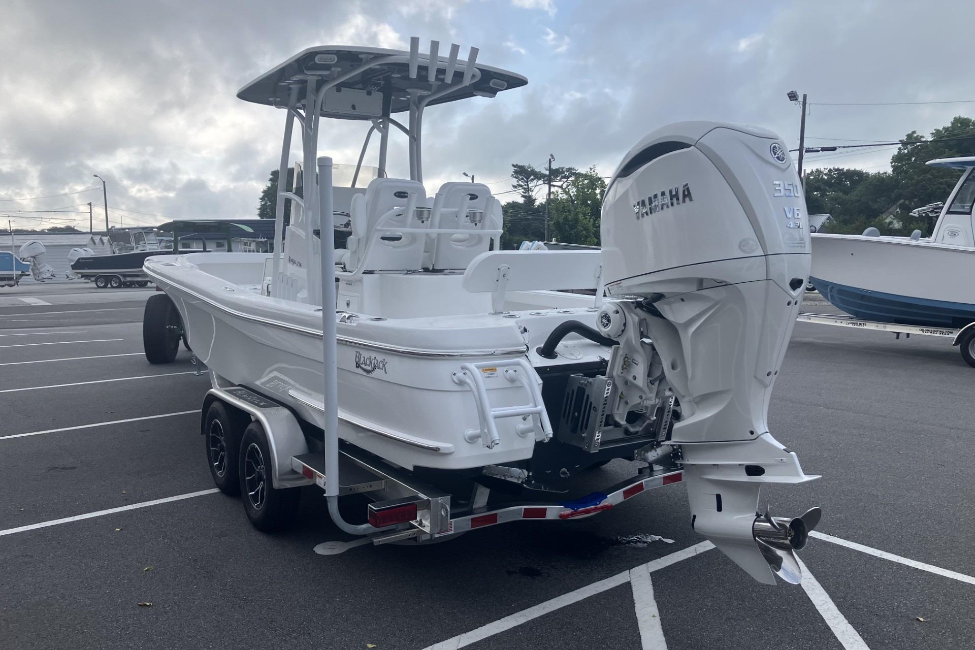 2026 BlackJack 256 Coastal boat with Yamaha engine on trailer in parking lot.