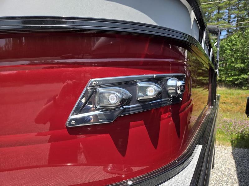 Close-up of 2025 Regency 230 DL3 boat's sleek red exterior with modern LED lights.