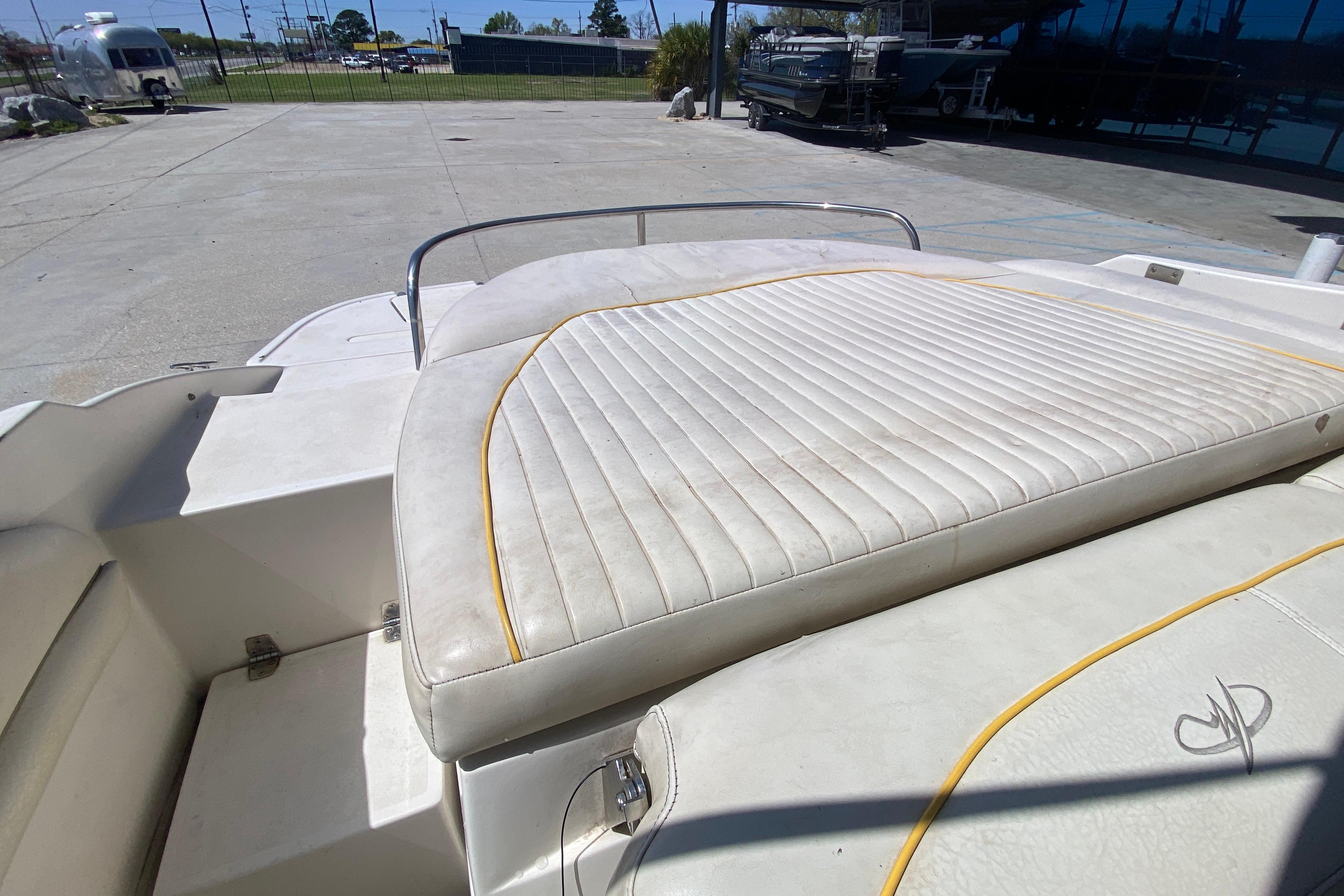 2003 Monterey 208SI Montura boat with white cushioned seating in a sunny outdoor setting.