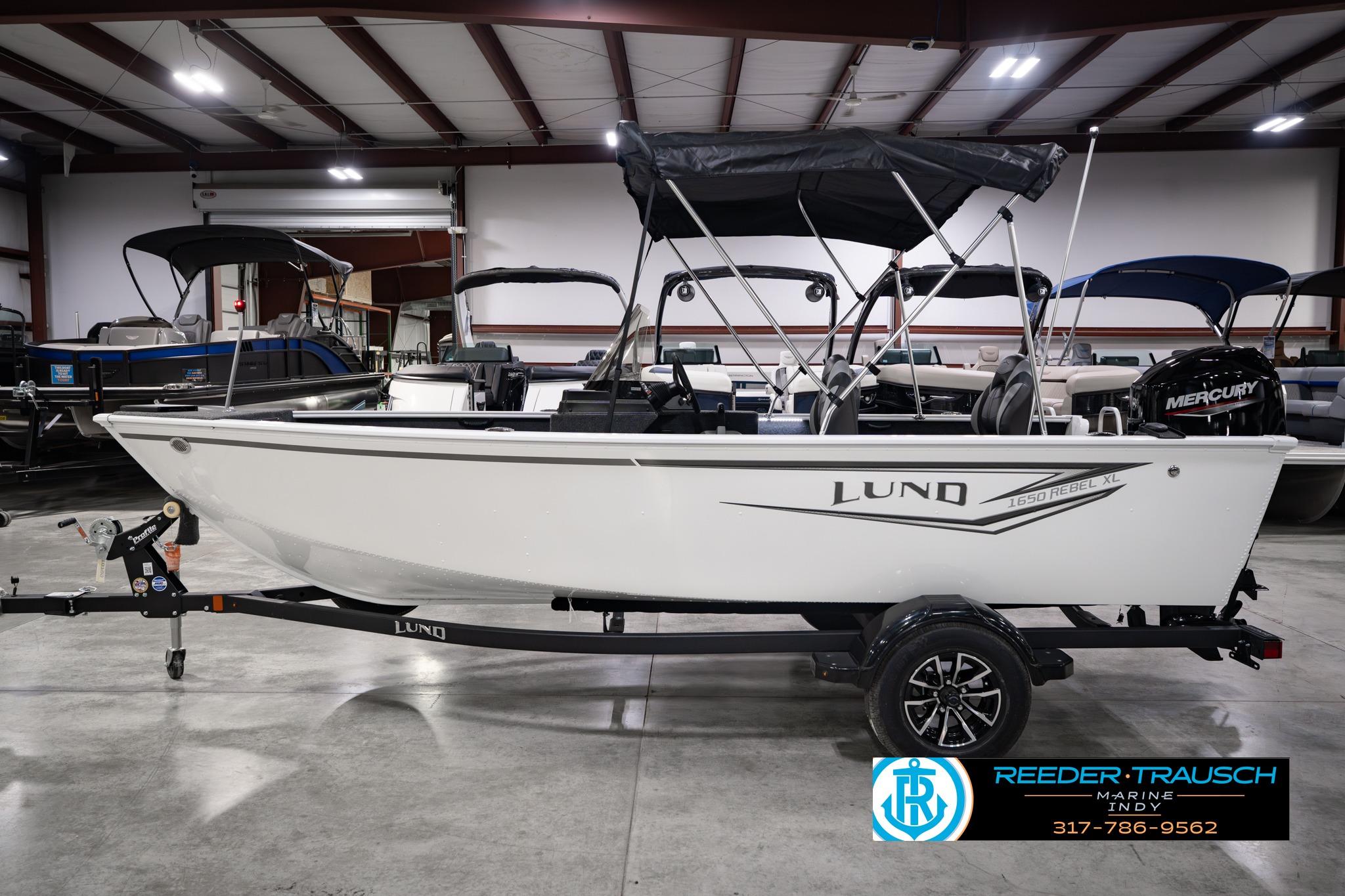2026 Lund 1650 Rebel XL SS boat in showroom, featuring a Mercury engine and canopy.