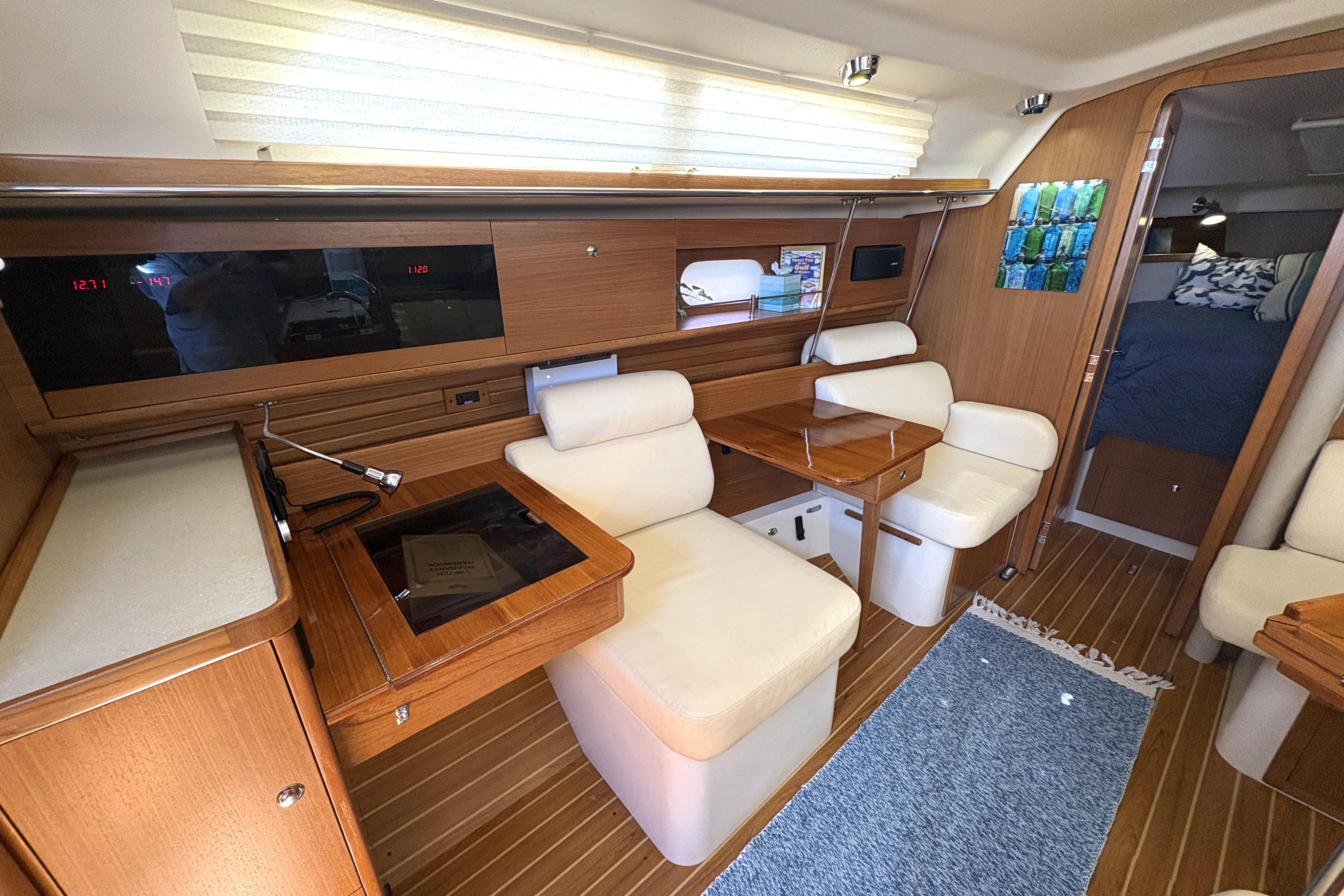 Interior of a 2011 Catalina 355 sailboat with wood finish and cozy seating area.